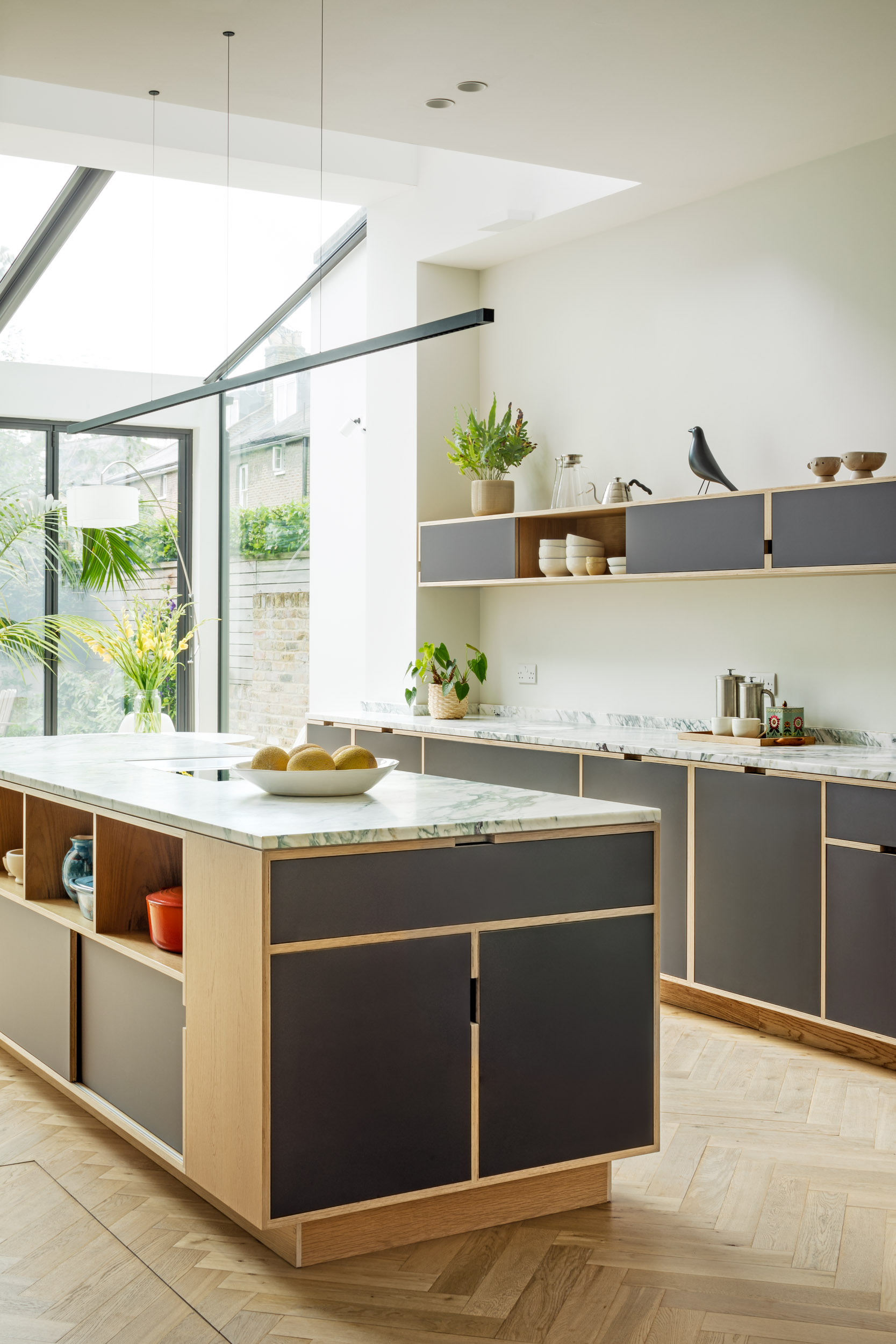 Glass extension with plywood kitchen and island in foreground