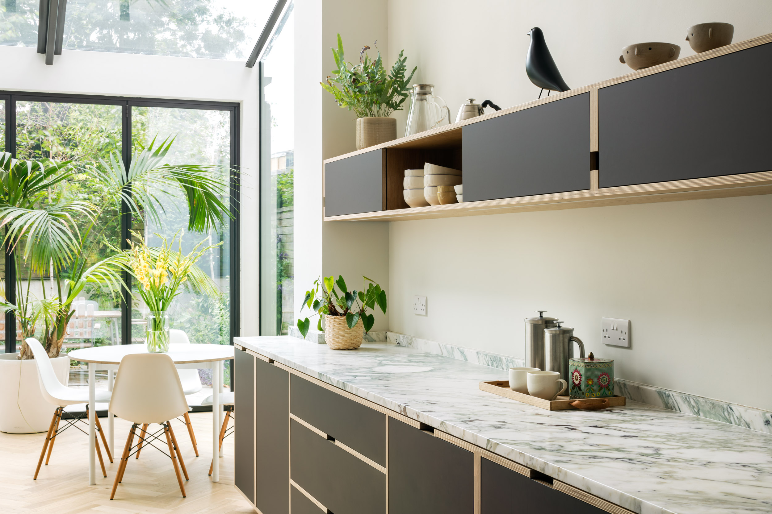 bespoke birch plywood kitchen with oak veneer, slimline shelving. View out to green garden.