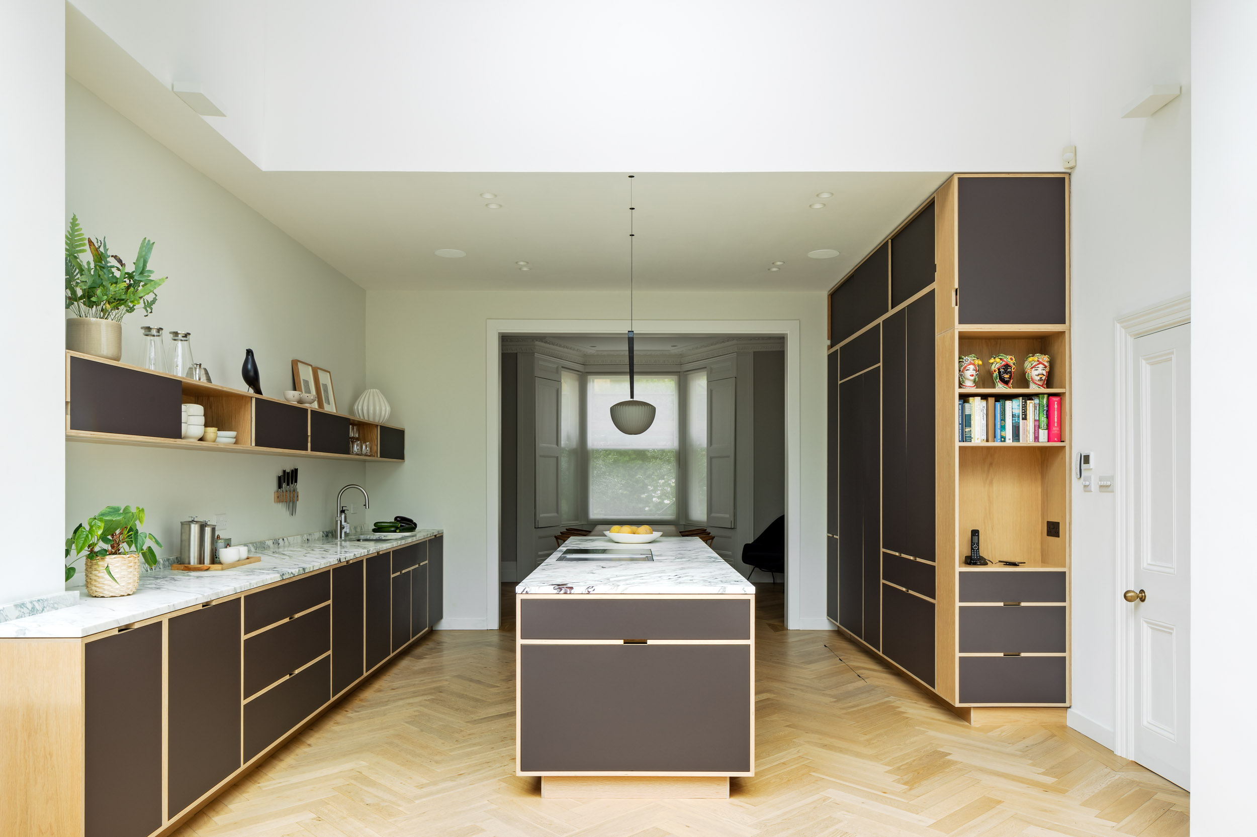 Victorian Villa internal view on bespoke birch plywood kitchen with oak veneer, island and narrow shelving. 