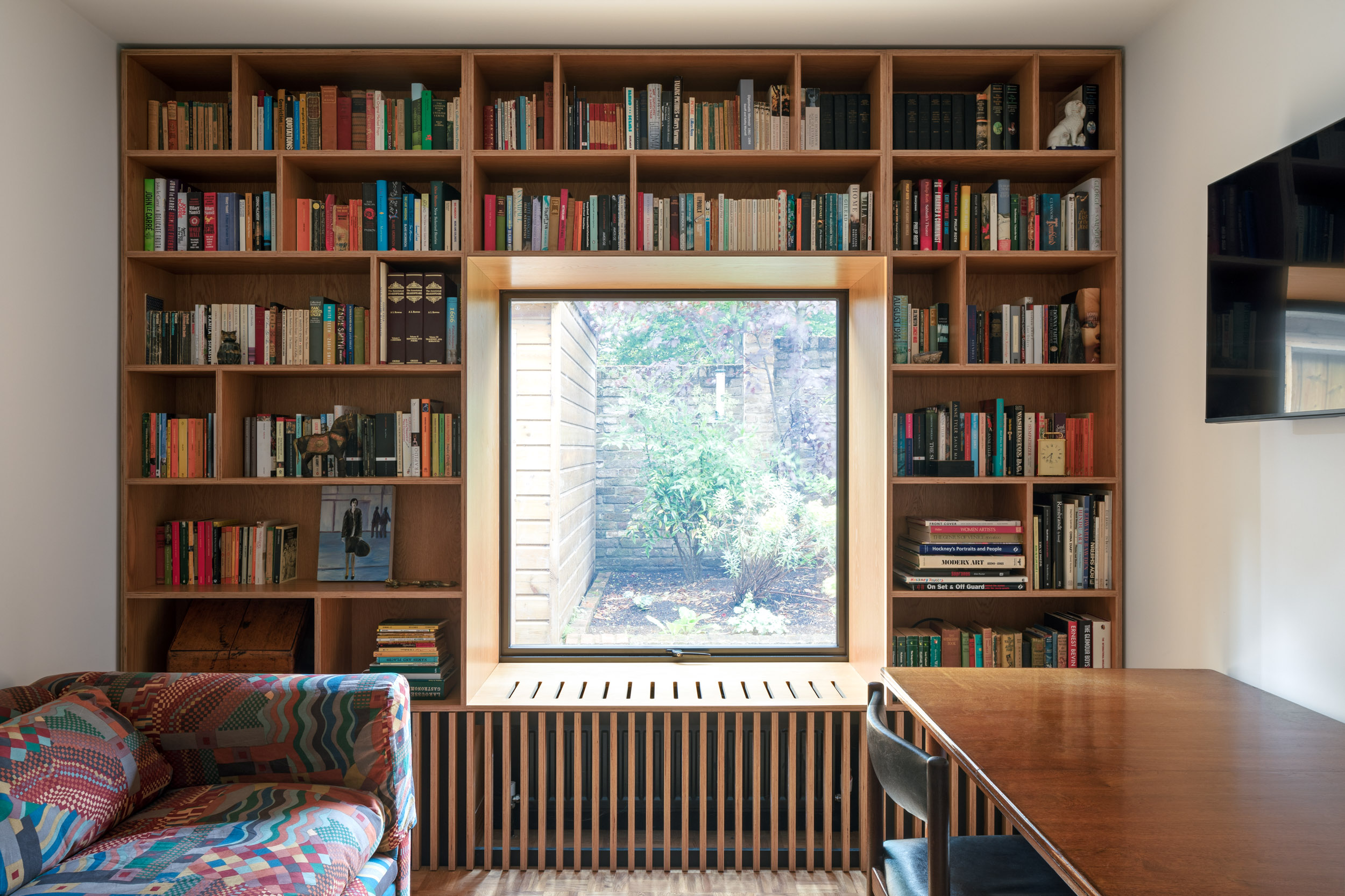 book collection on bookcase made to surround window with seating