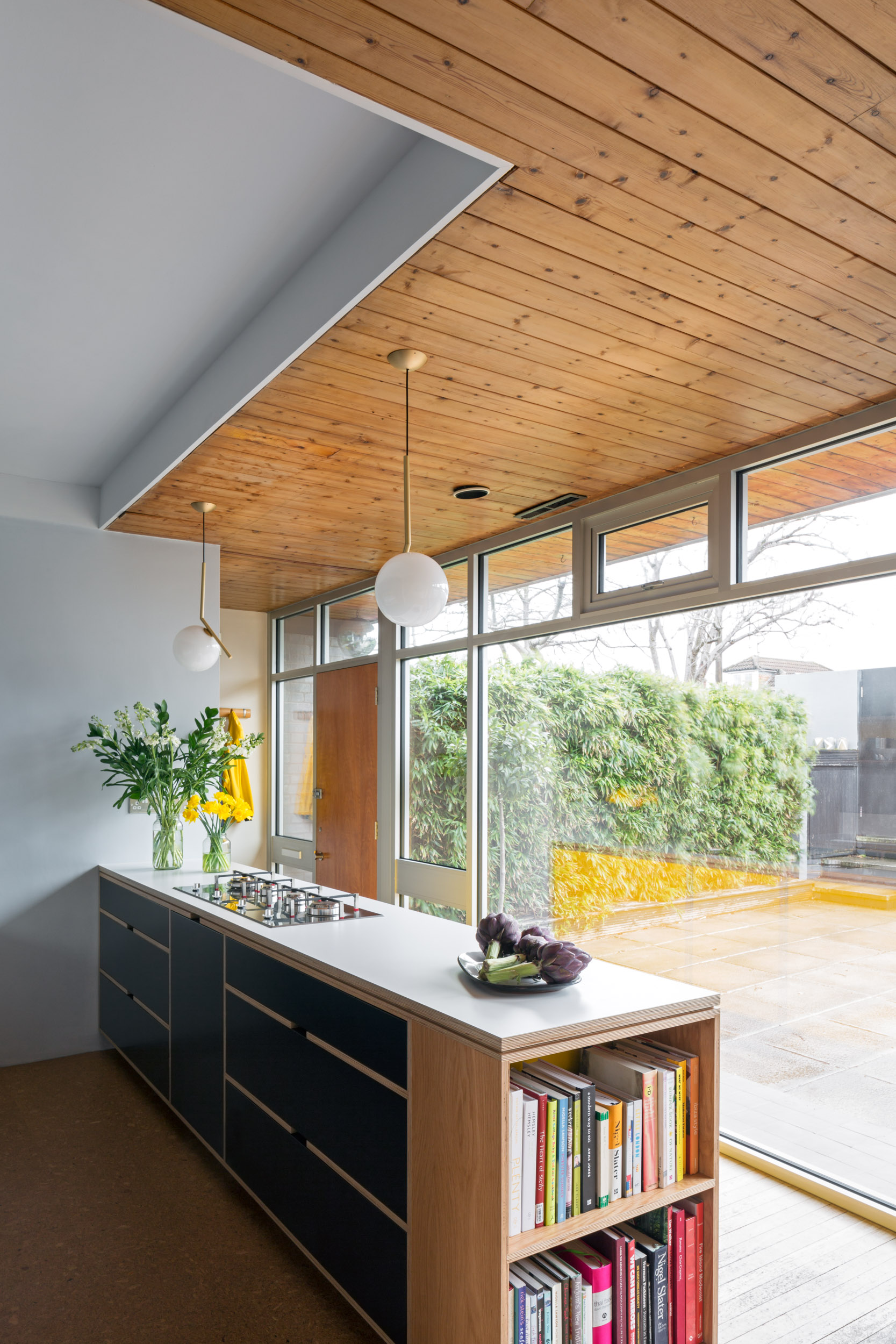 Wood panelled celing above a plywood kitchen