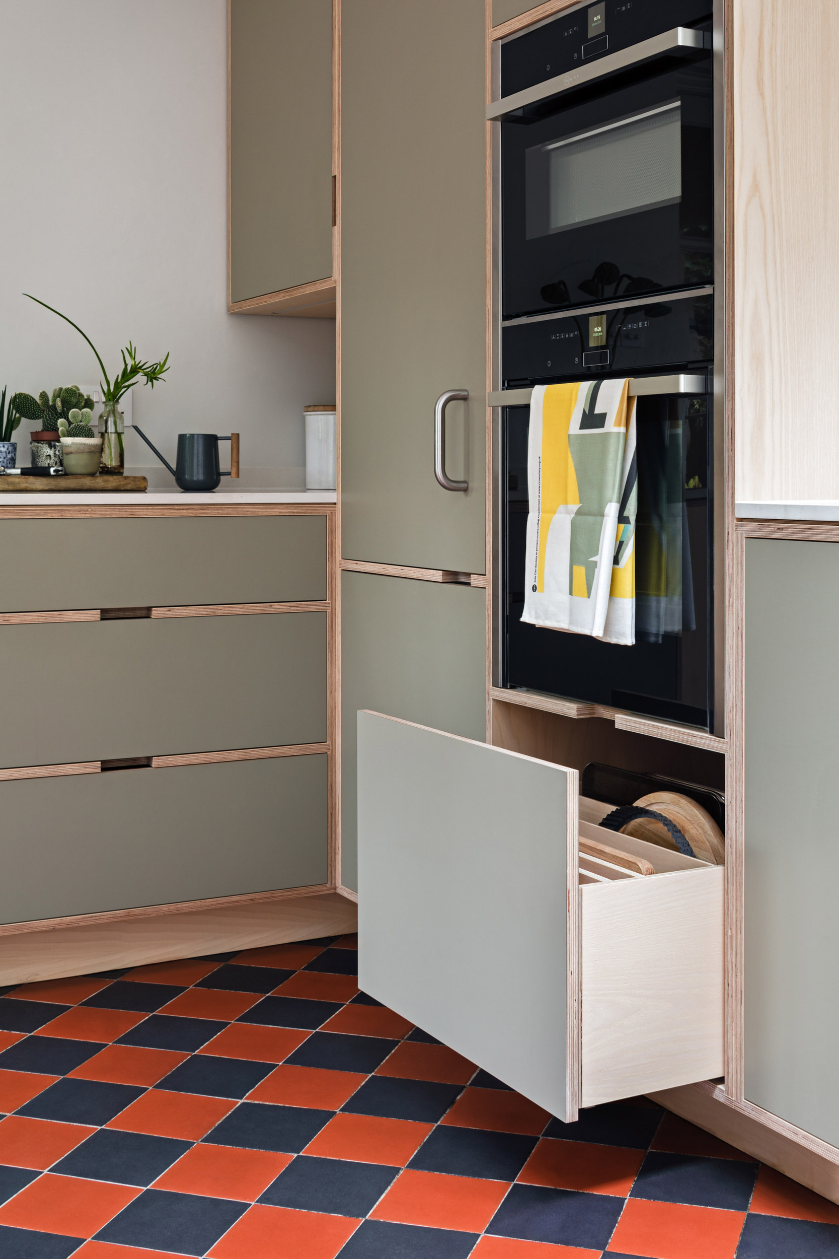 Bespoke plywood drawers with integrated ovens and ash veneer detailing by Uncommon Projects.