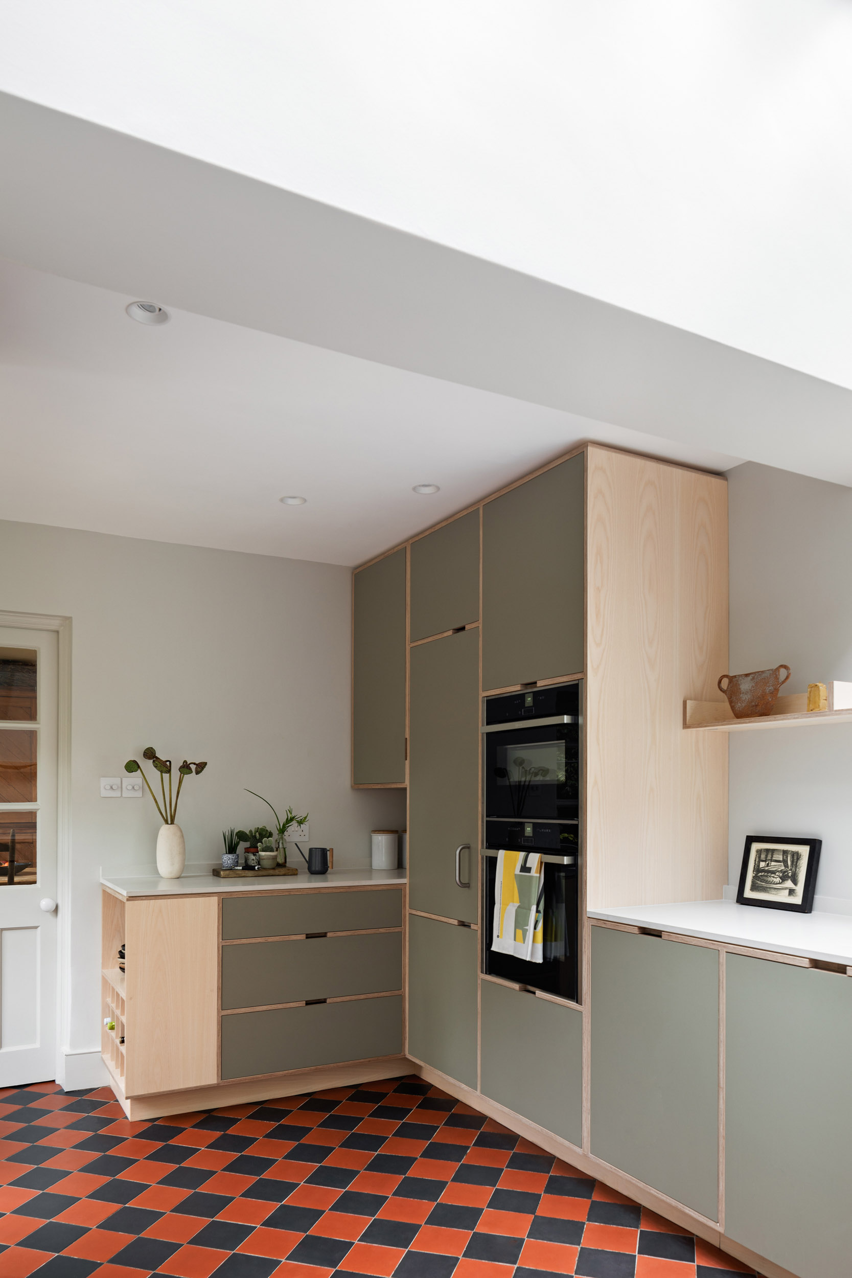 Minimal plywood kitchen with integrated island, ash finishes and open-plan layout designed by Uncommon Projects for a period cottage.