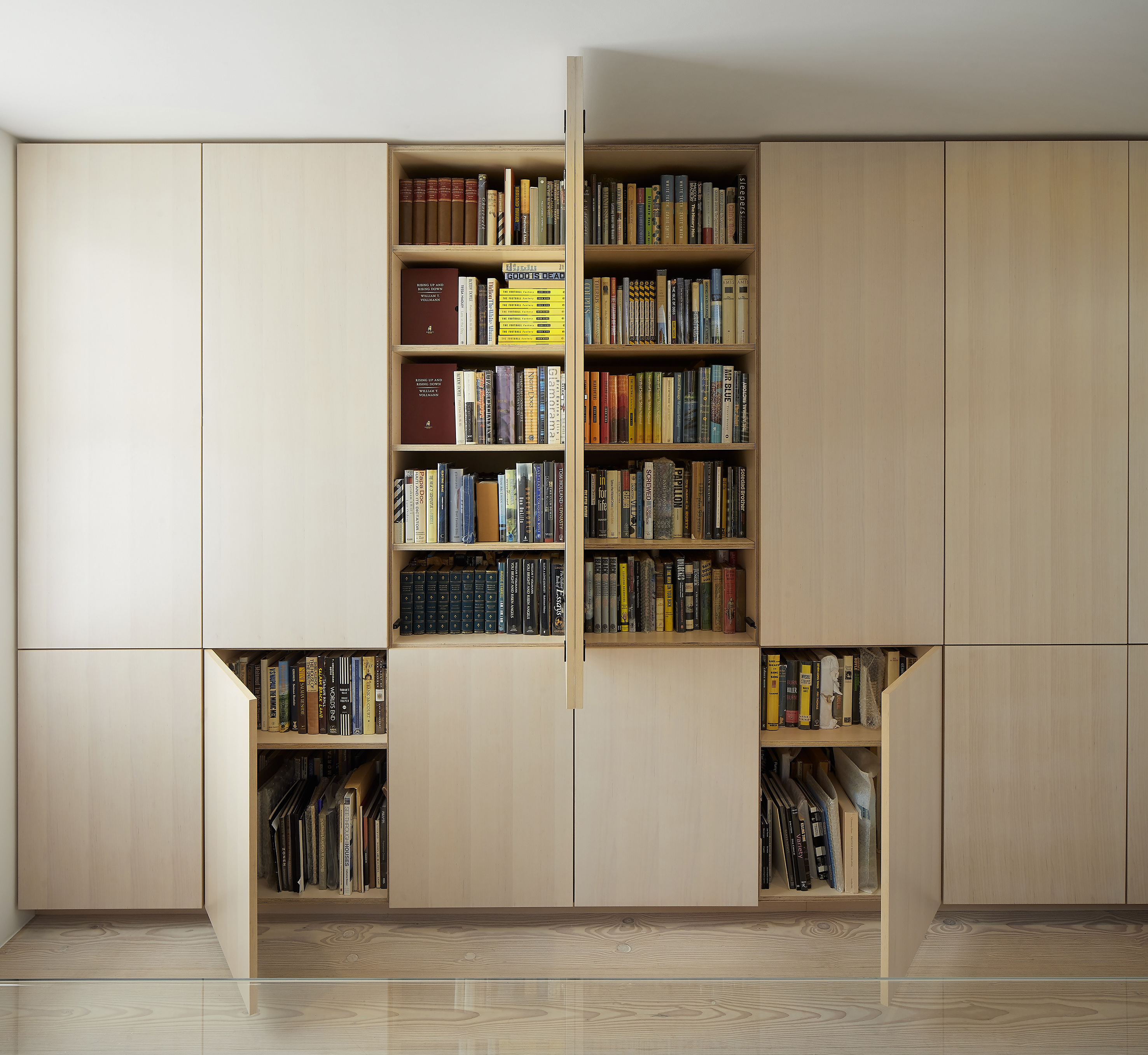 Ash wood veneer cupboards used for book storage. Open and closed doors.