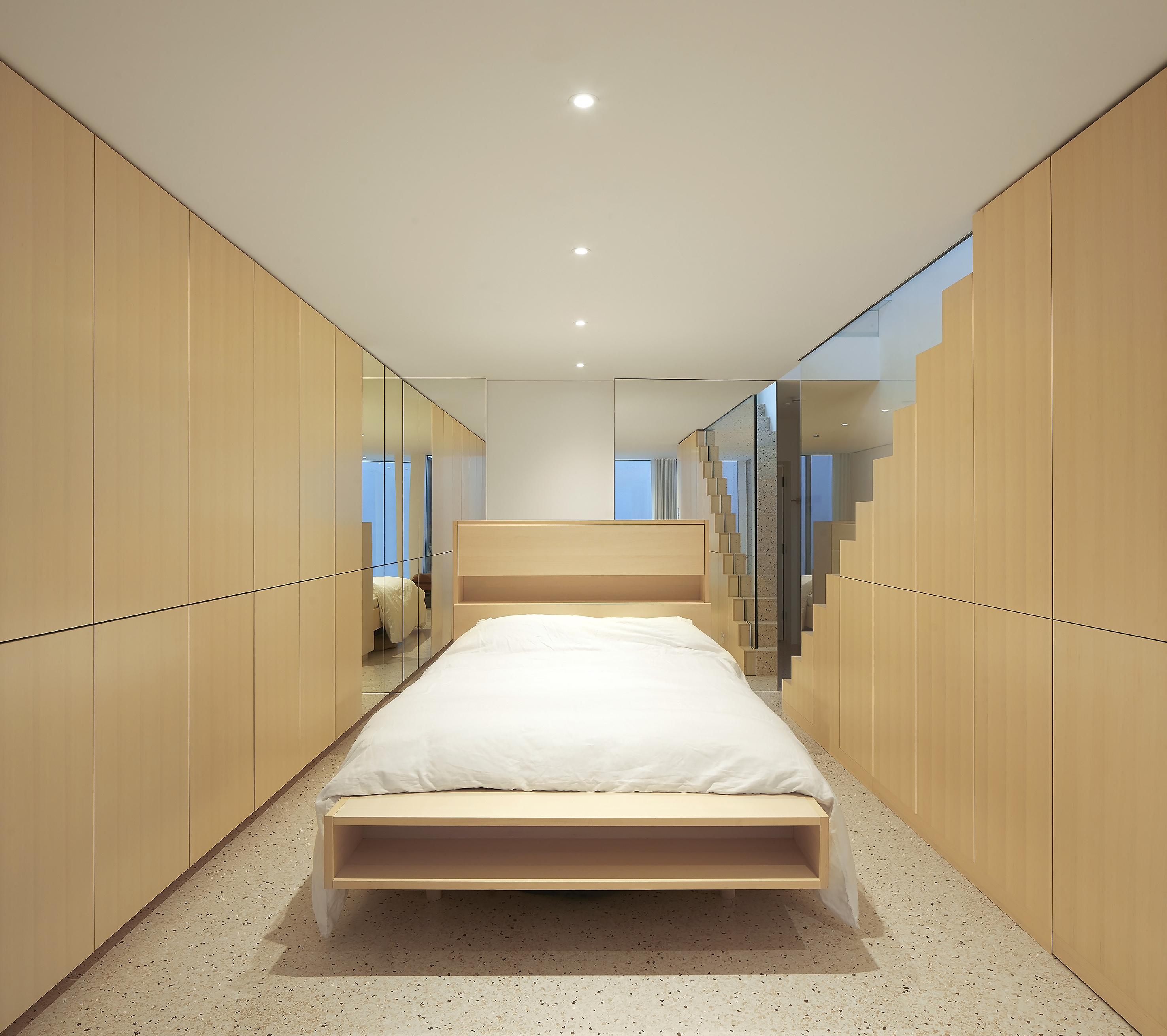 Minimalist modern ash plywood panelling, storage and bespoke bed.