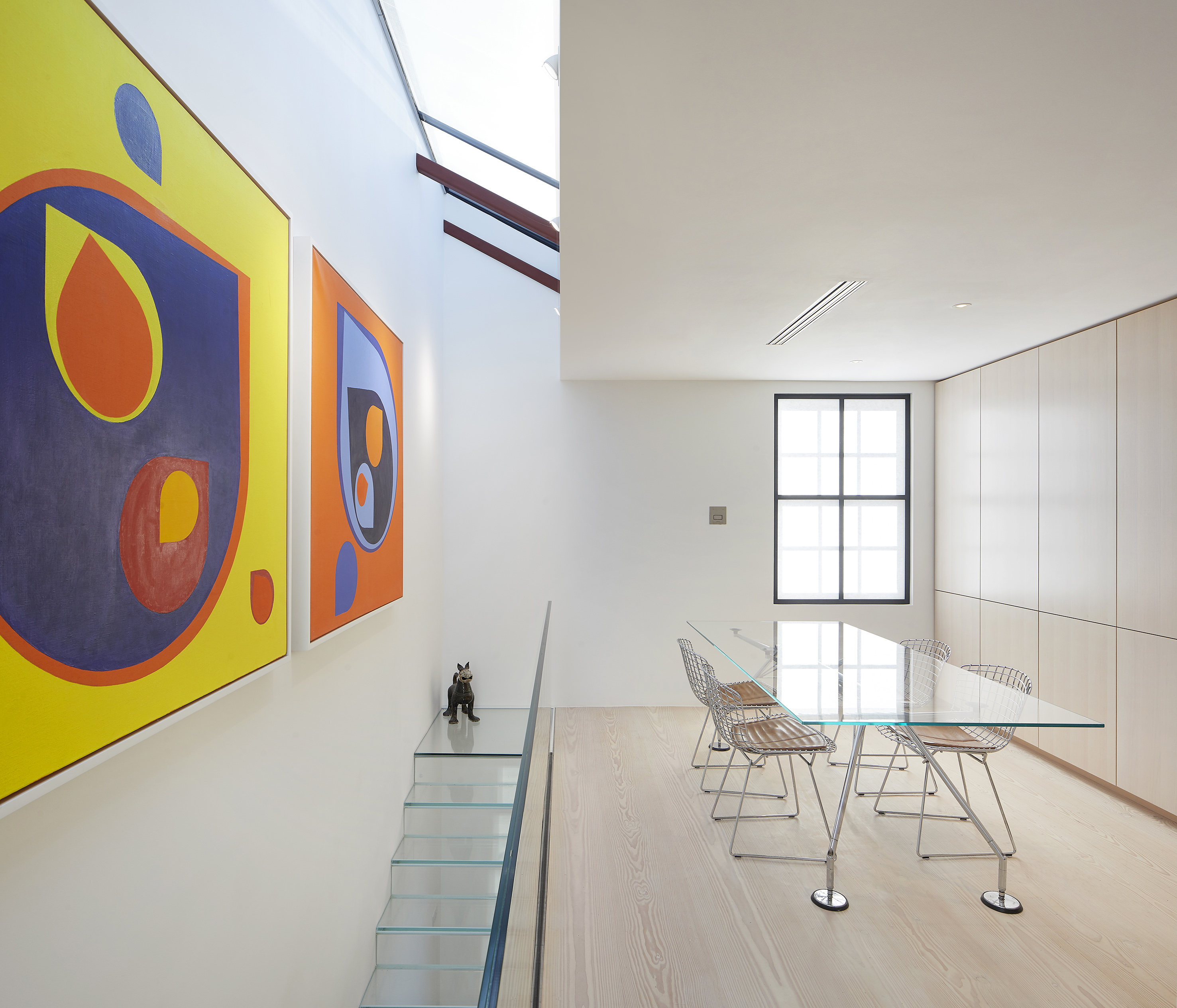Art, skylight, glass stairs and table and an ash book storage/ wardrobe