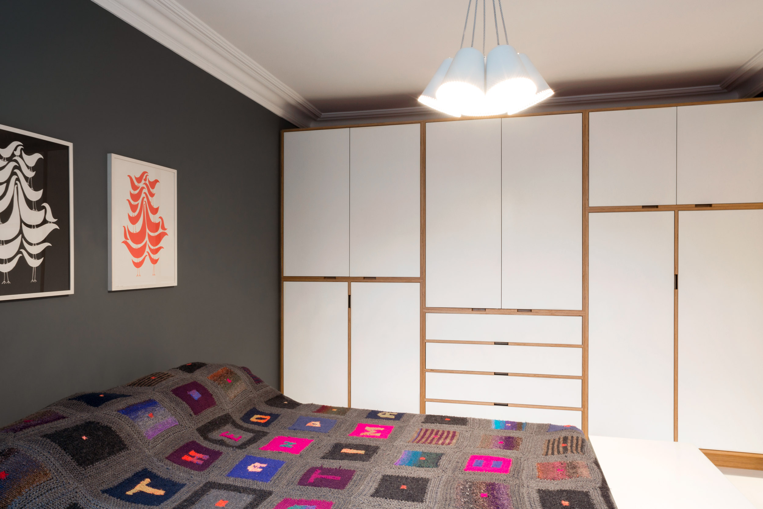 A full height ply wardrobe with white doors in a bedroom.