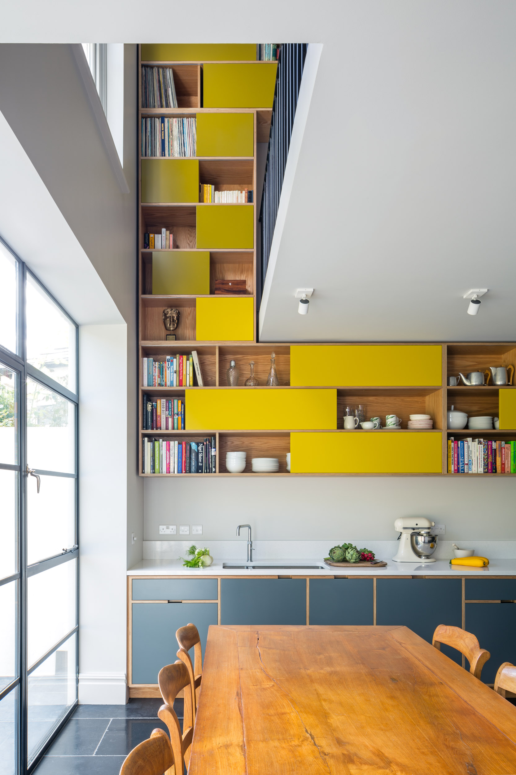 Double height yellow sliding door wall cabinetry