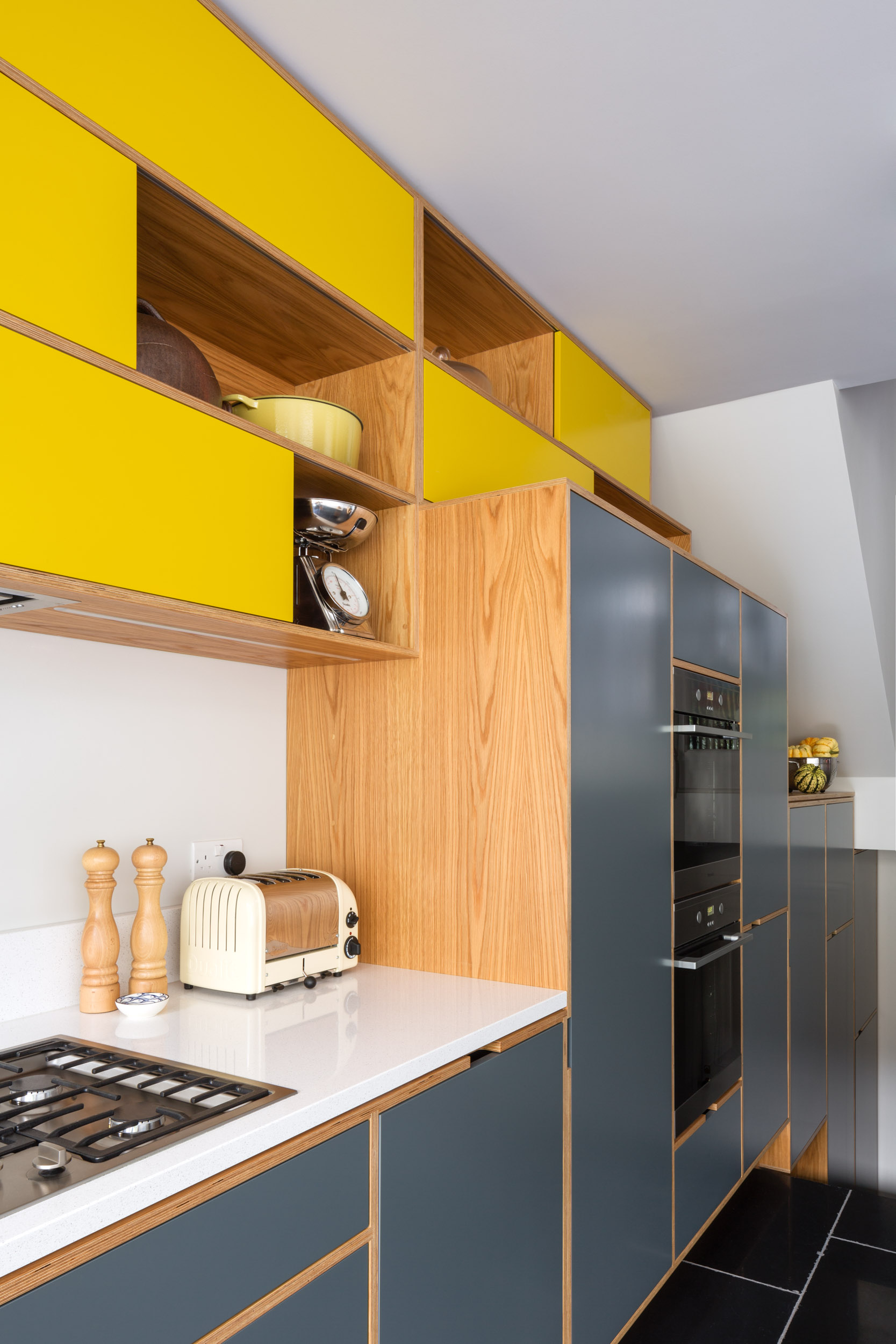 Detail Light grey plywood kitchen with yellow sliding door wall cabinets