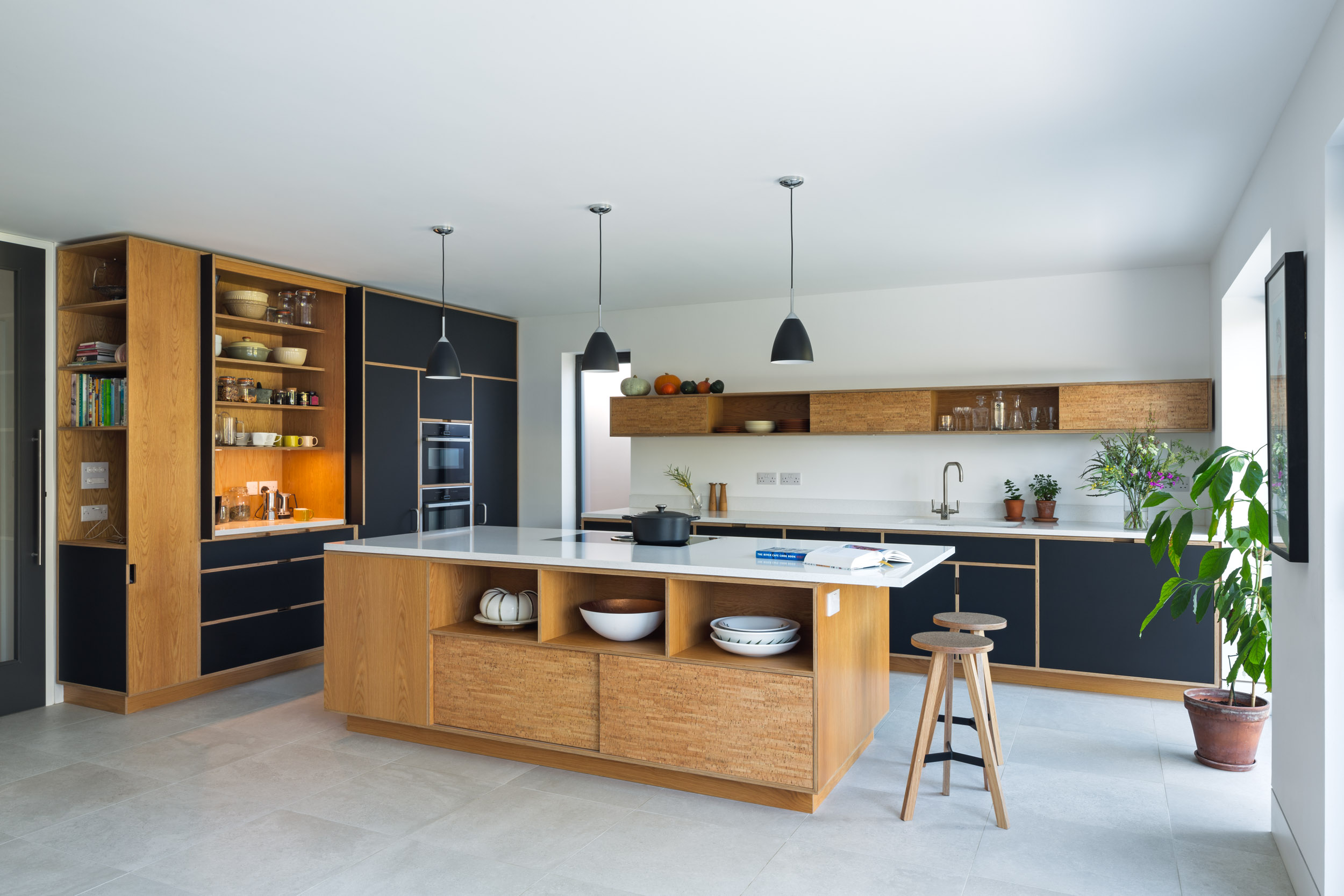 Bespoke plywood kitchen cabinetry including large island, in cork veneer and black fenix laminate finish