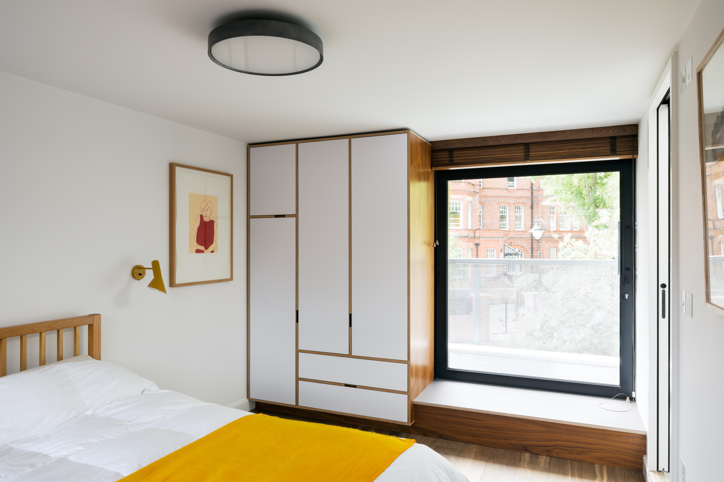 Walnut fitted furniture with wardrobes and bench seating