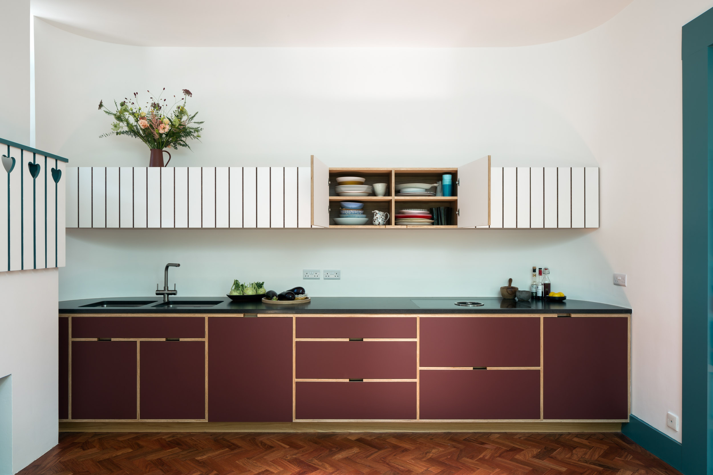 Maroon and white kitchen cabinetry with ply frame detailing