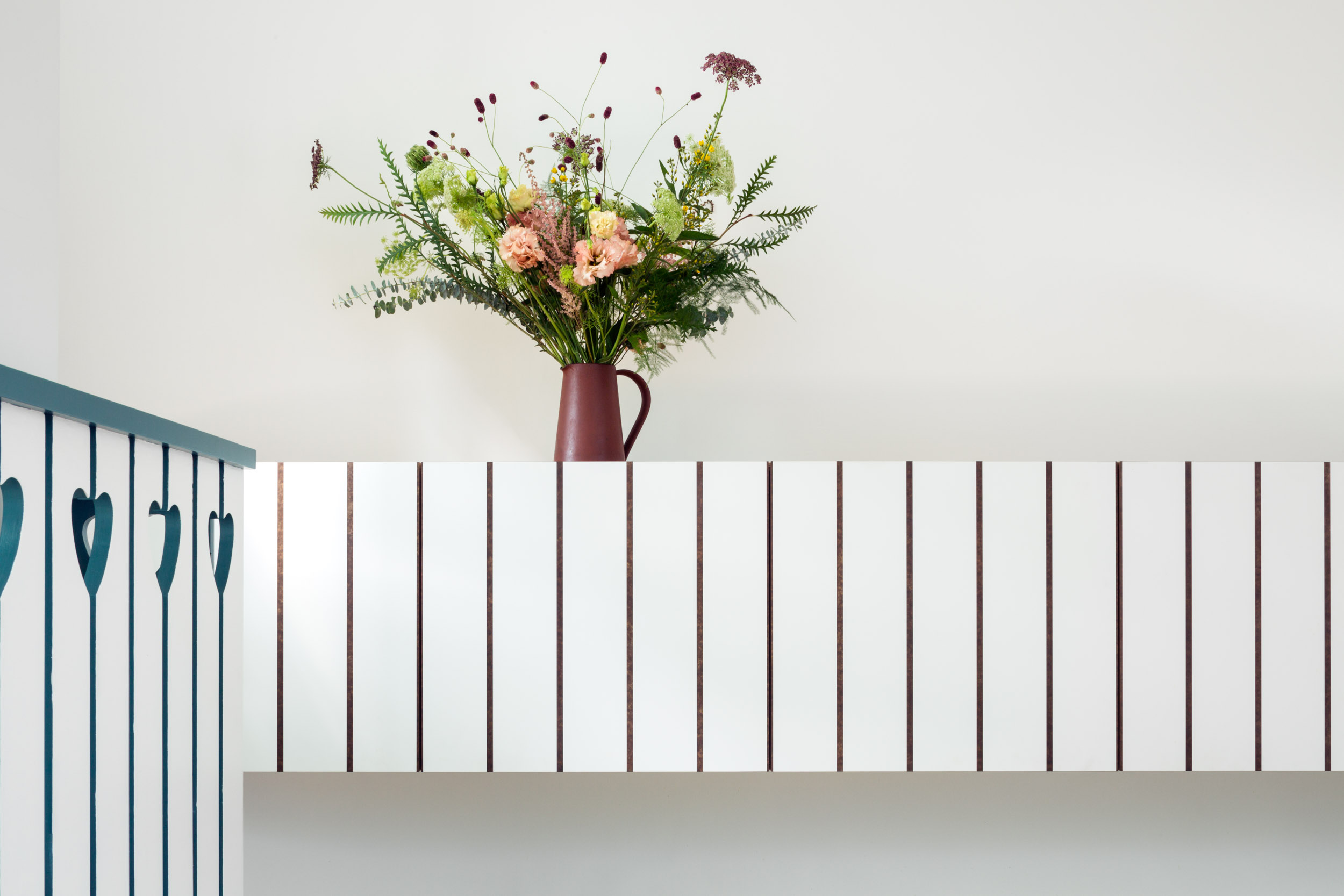 White wall cabinet with striped rebate detail