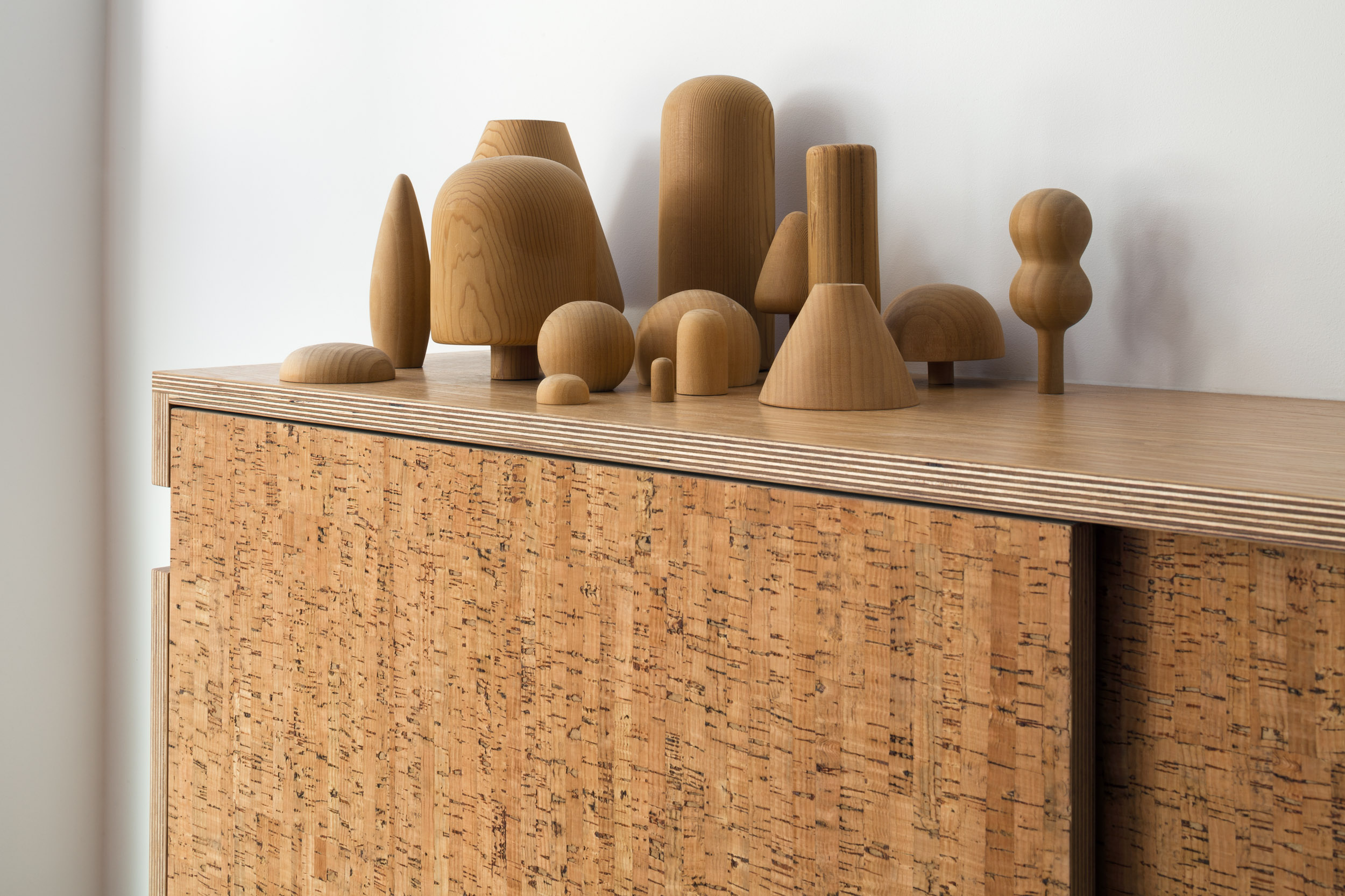 Cork sliding door sideboard with carved wood objects