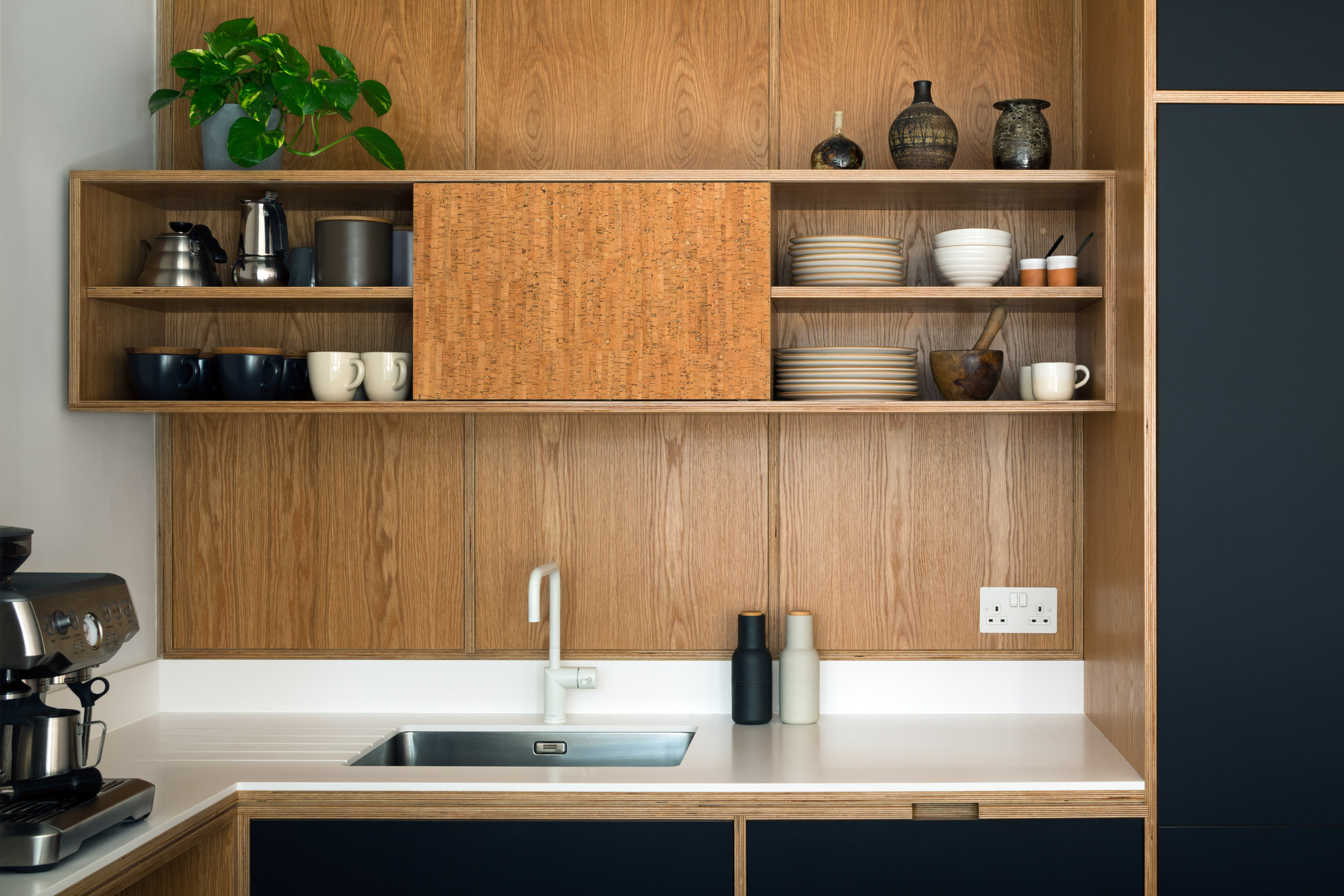 Oak veneer, corian worktop and black doors on a bepoke plywood kitchen, close up shot