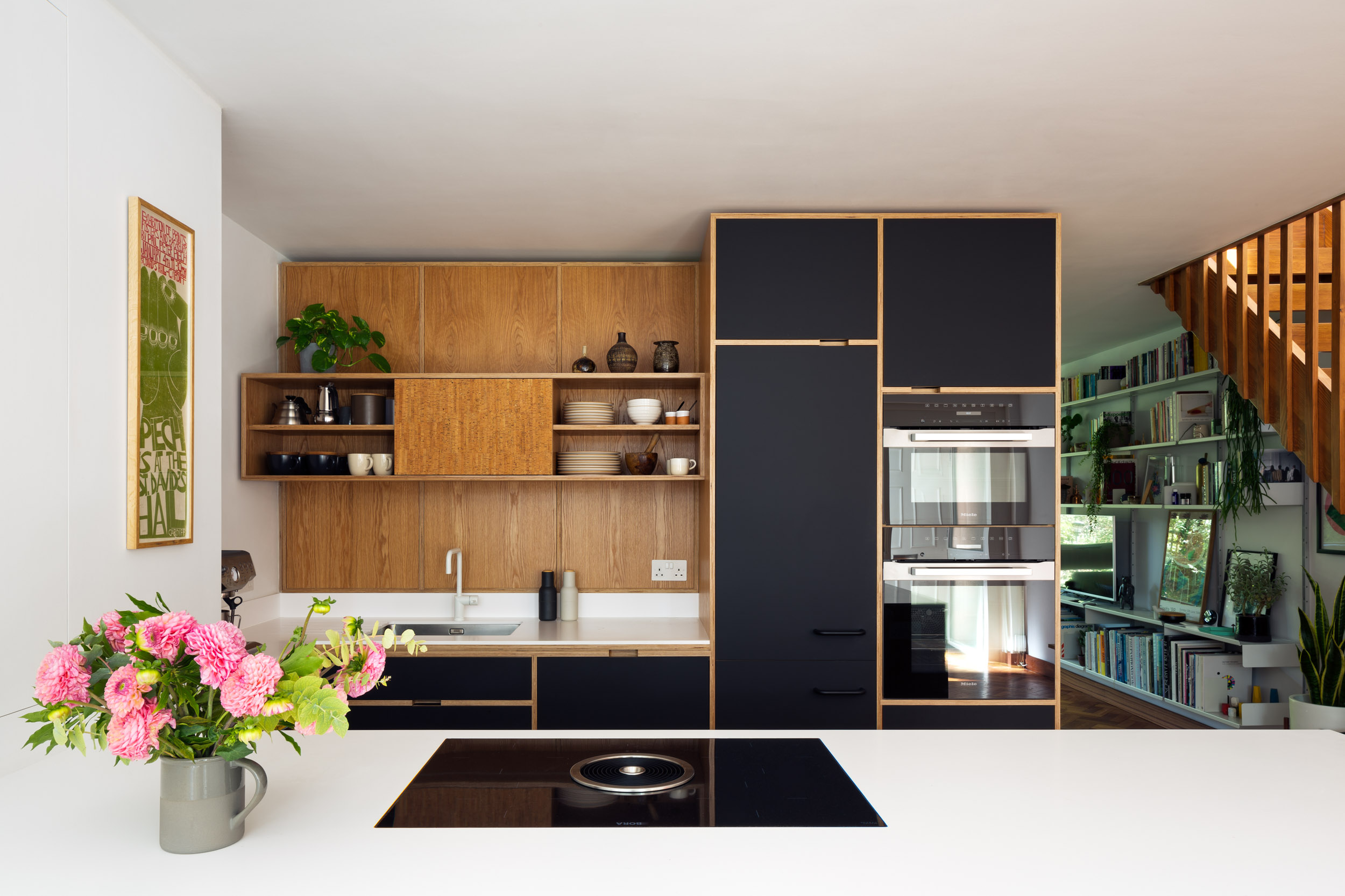 Oak veneer, corian worktop and black doors on a bepoke plywood kitchen, mid-distance shot