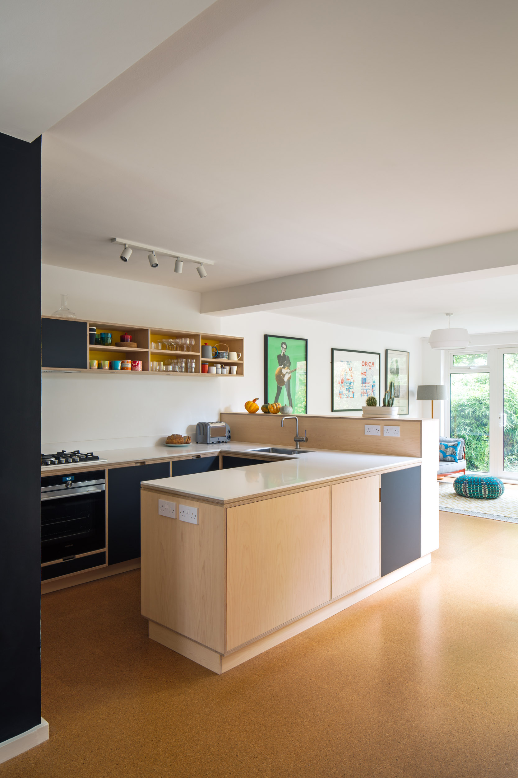 Maple peninsula with corian worktop. Black doors
