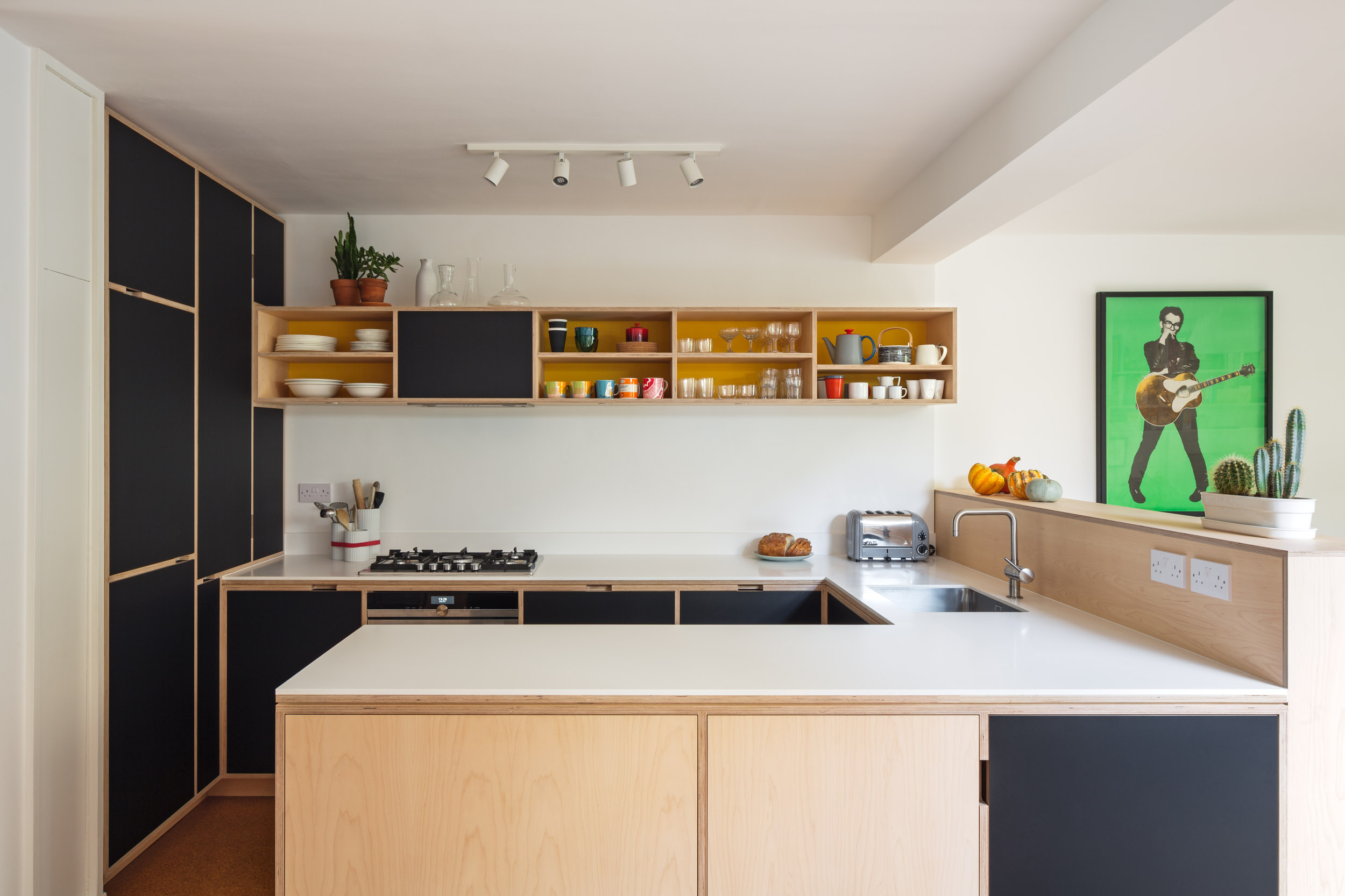 Maple peninsula with corian worktop. Black doors. Birch ply bespoke kitchen