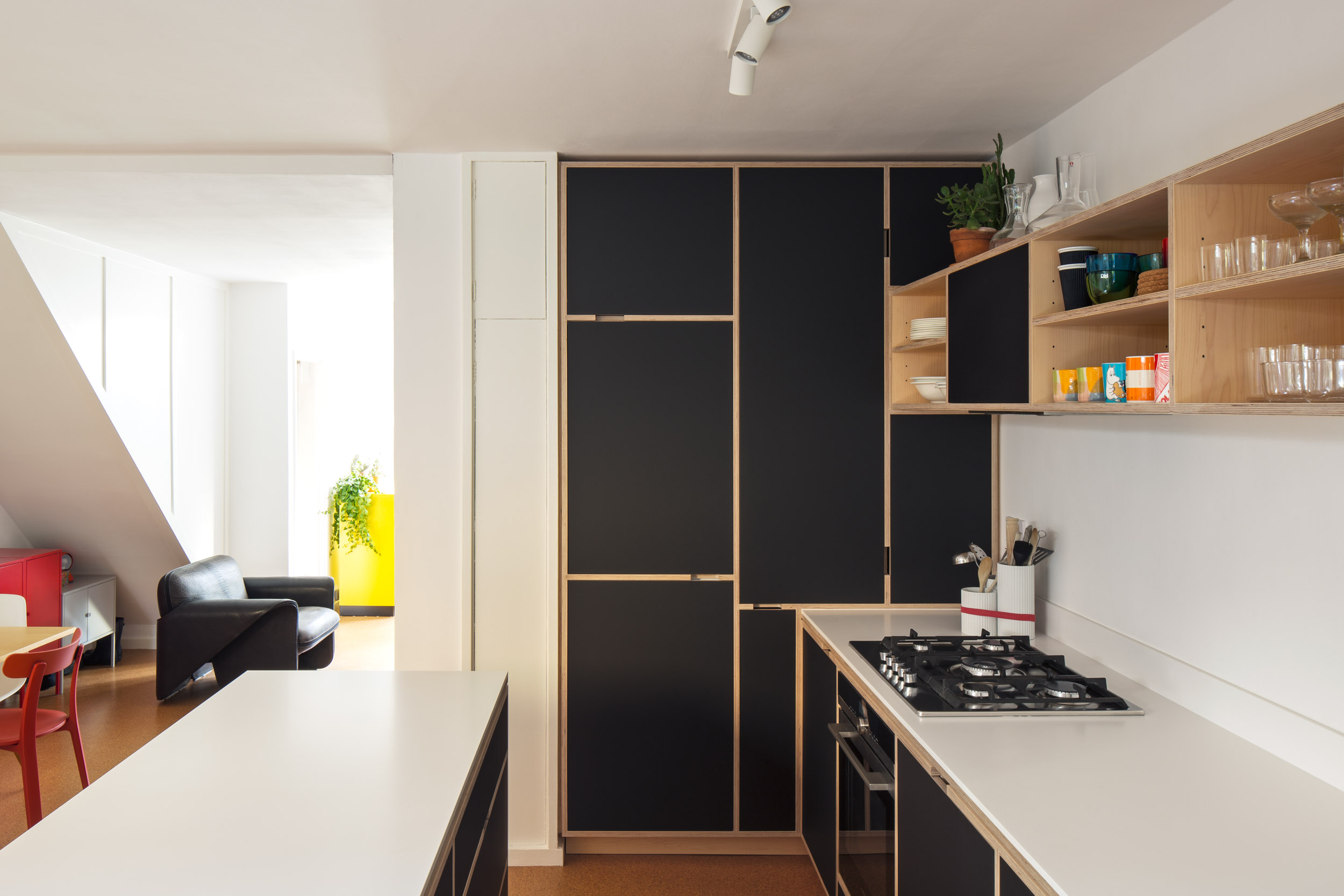 Bespoke full height kitchen cabinetry with corian worktop. Black doors.