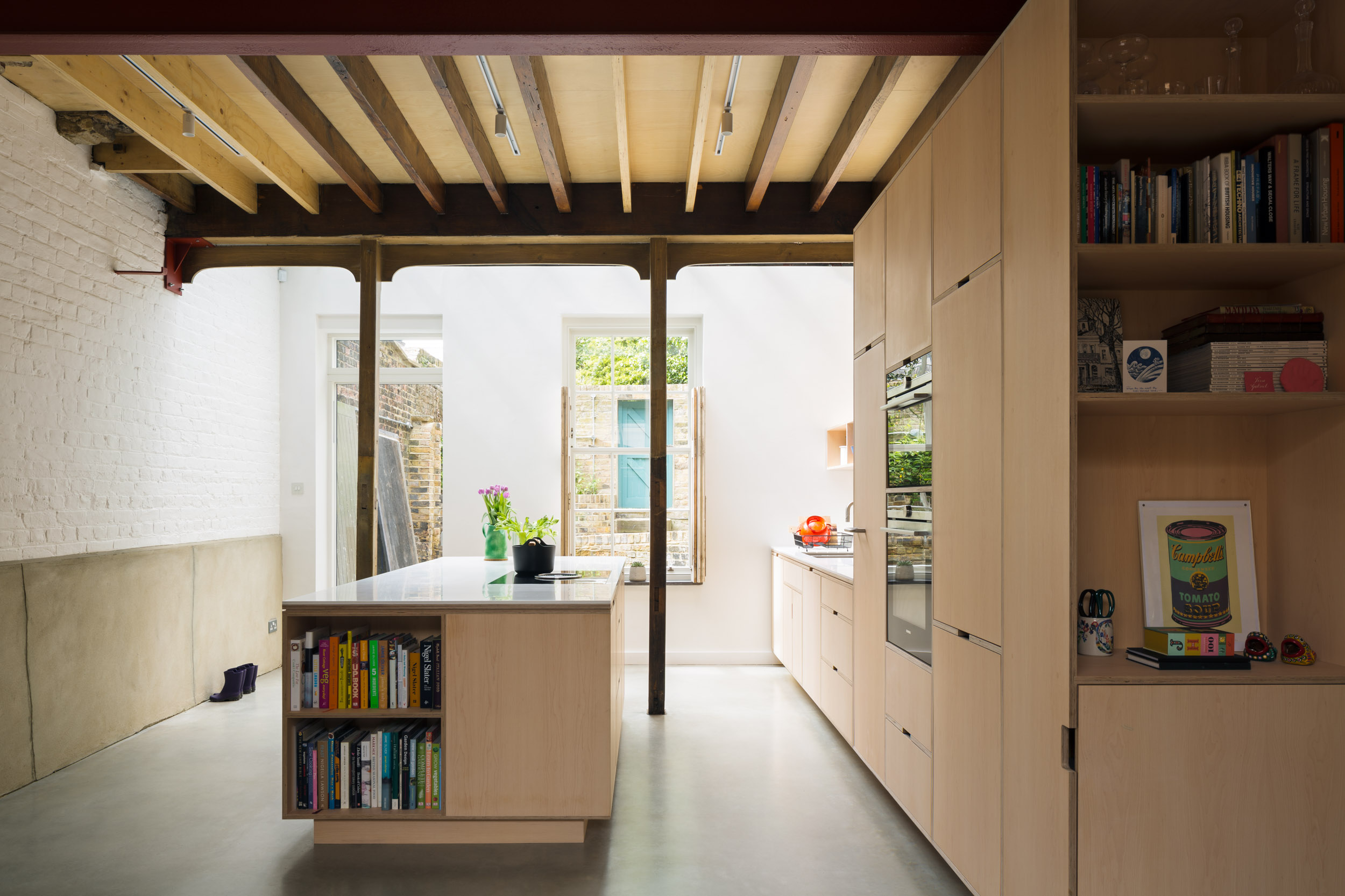 Maple veneered plywood kitchen in a coach house with exposed beams