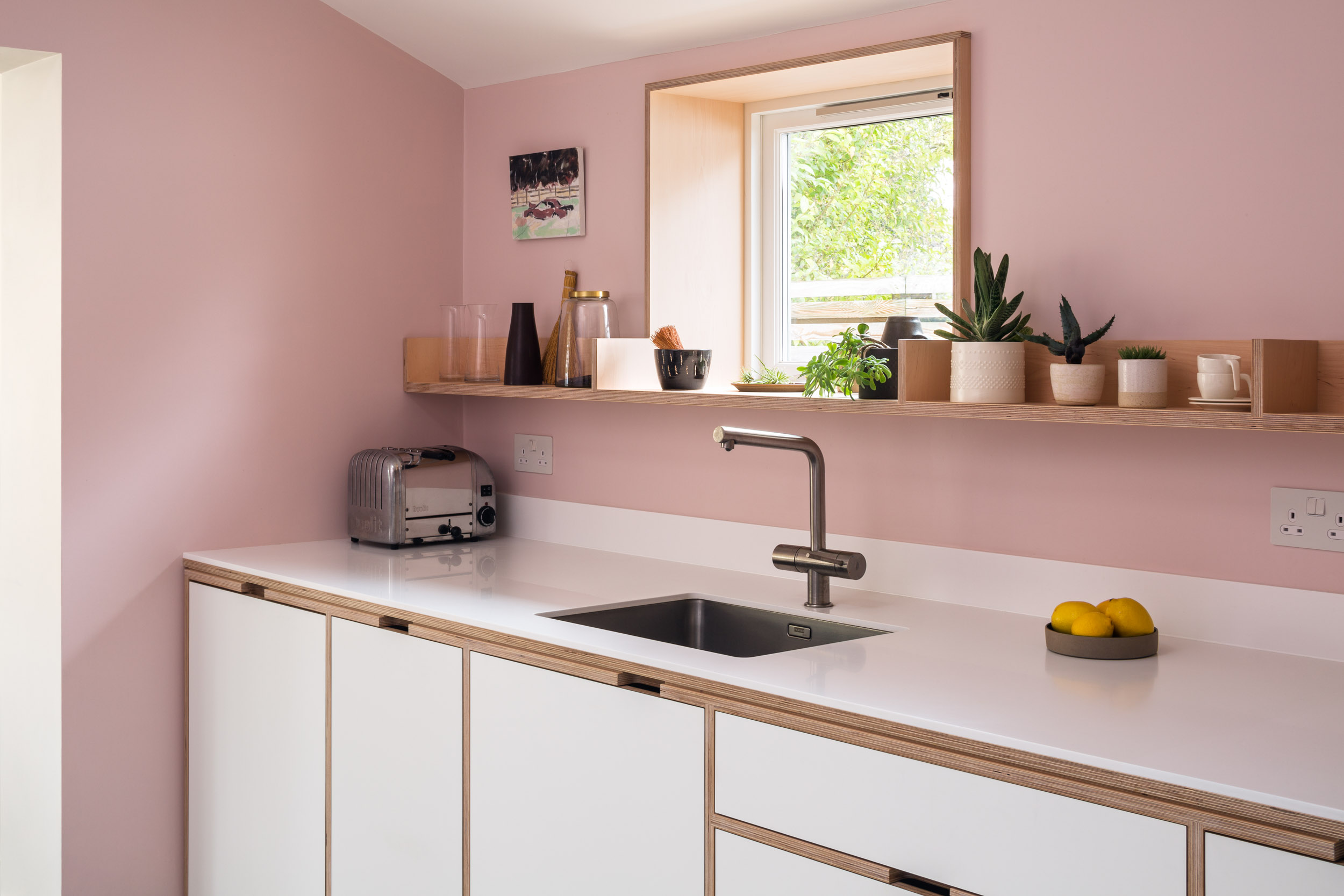White corian worktop with maple plywood open shelving