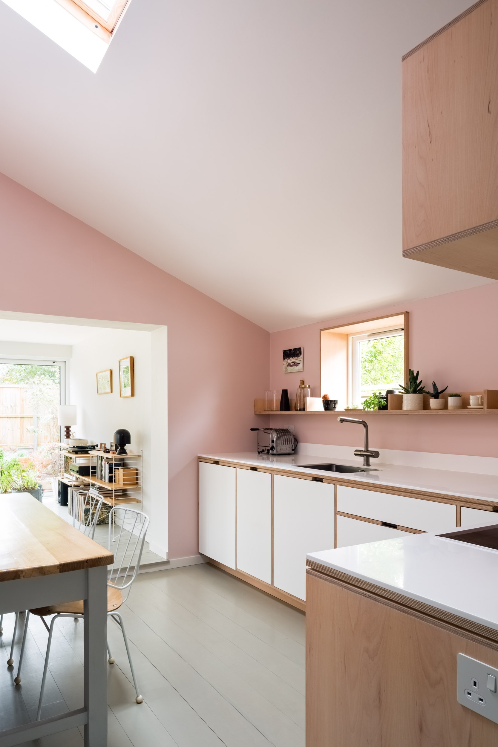 Pink walls and a maple plywood kitchen