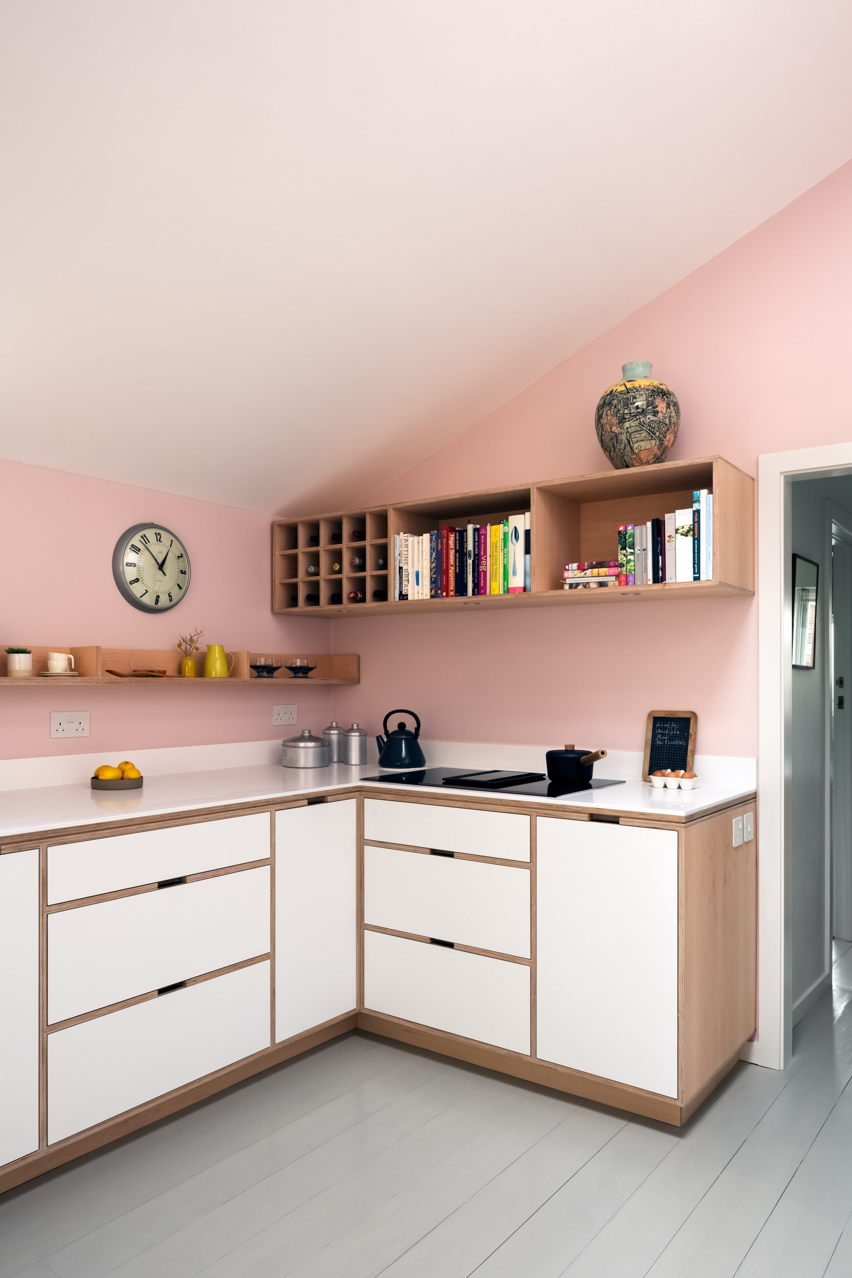 Pink walls and a maple plywood kitchen