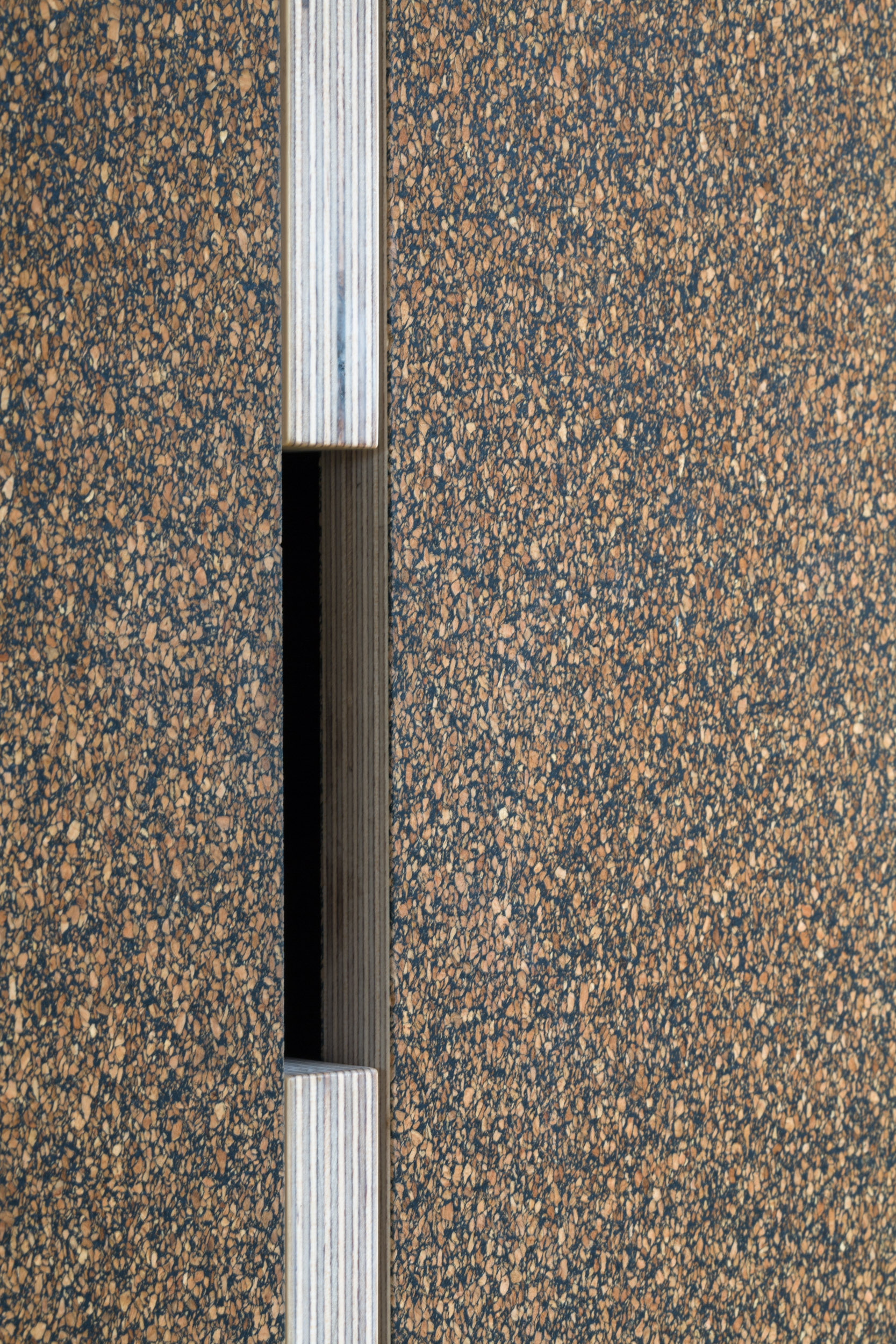 Detail of cabinetry and handle cut out with cork veneer.