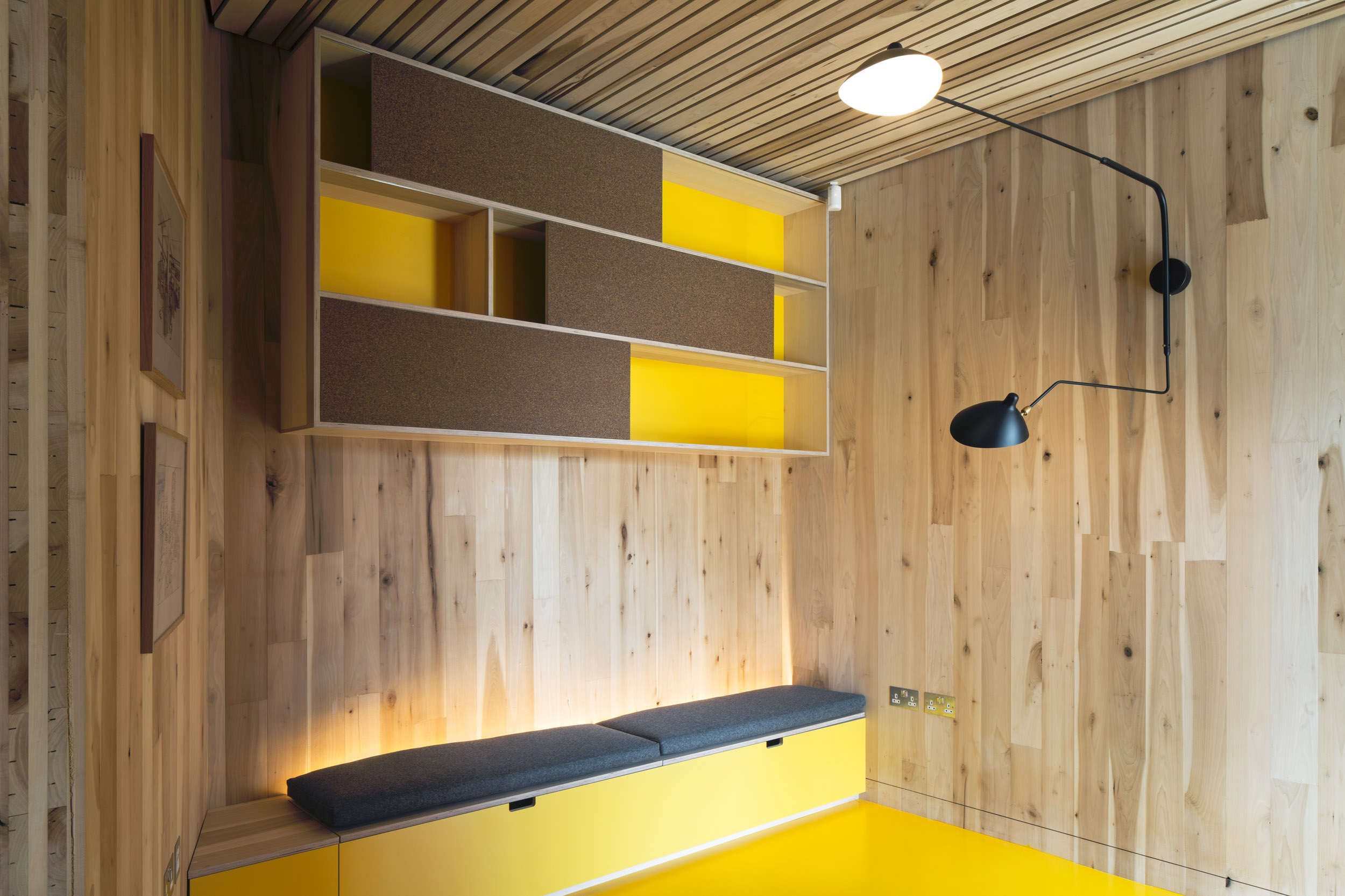 Built-in bench and high shelving with a yellow and cork finish. Douglas fir walls