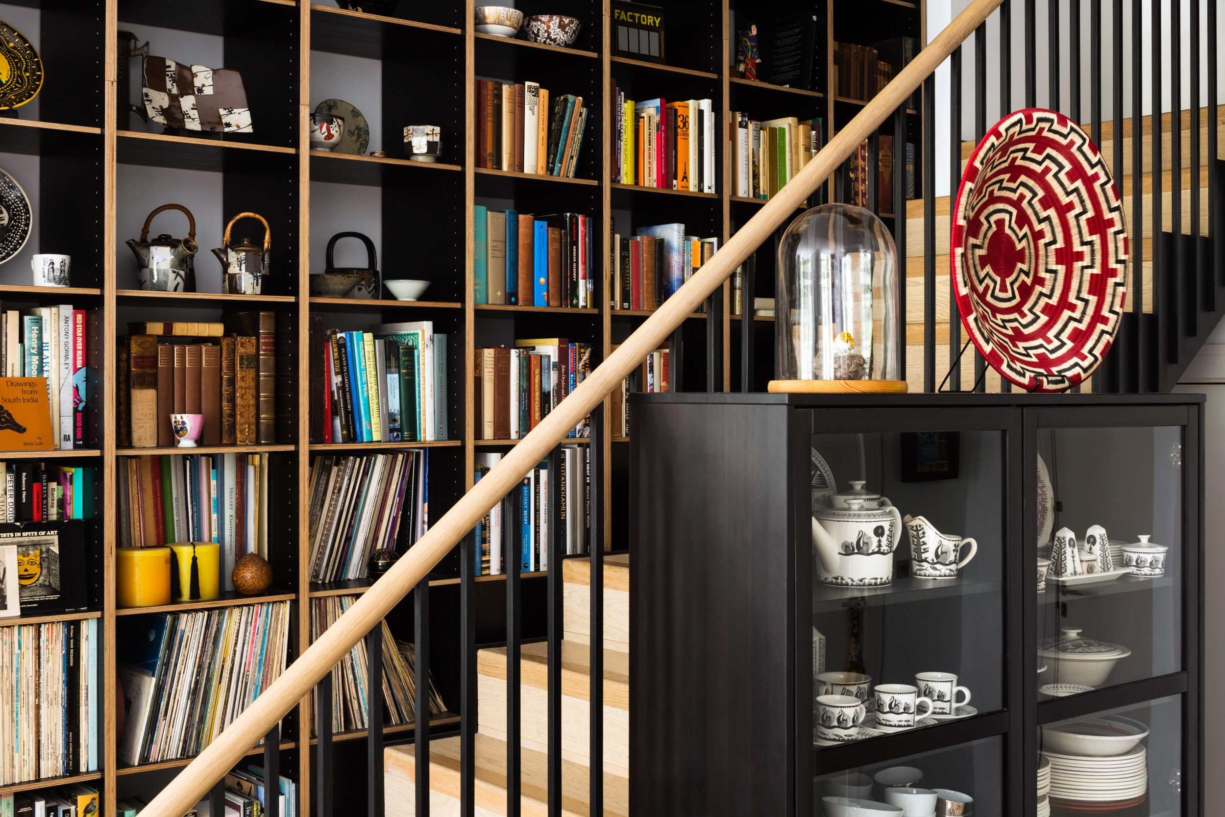 Dyed black veneer ply shelving over staircase