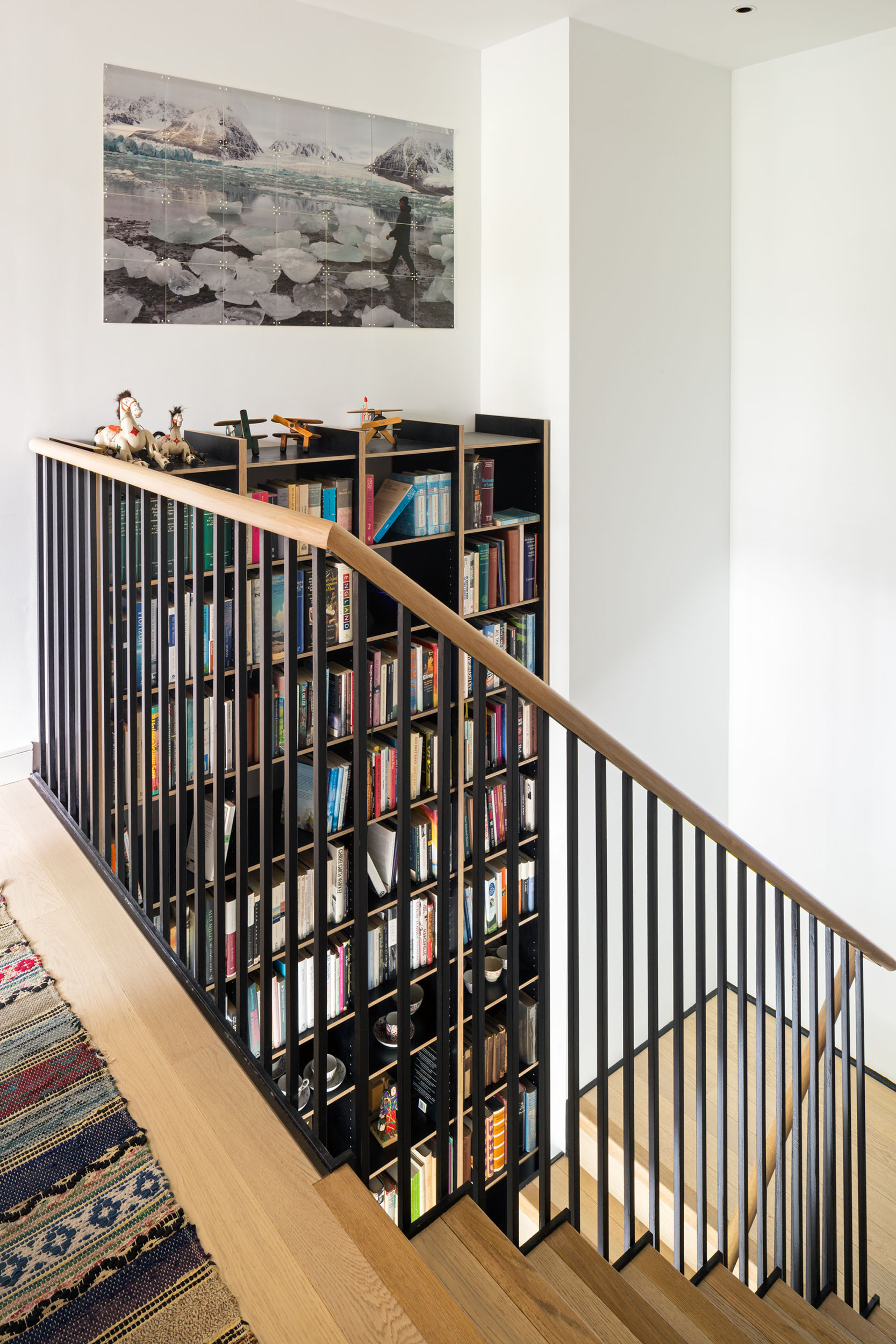 Double height ply shelving over staircase