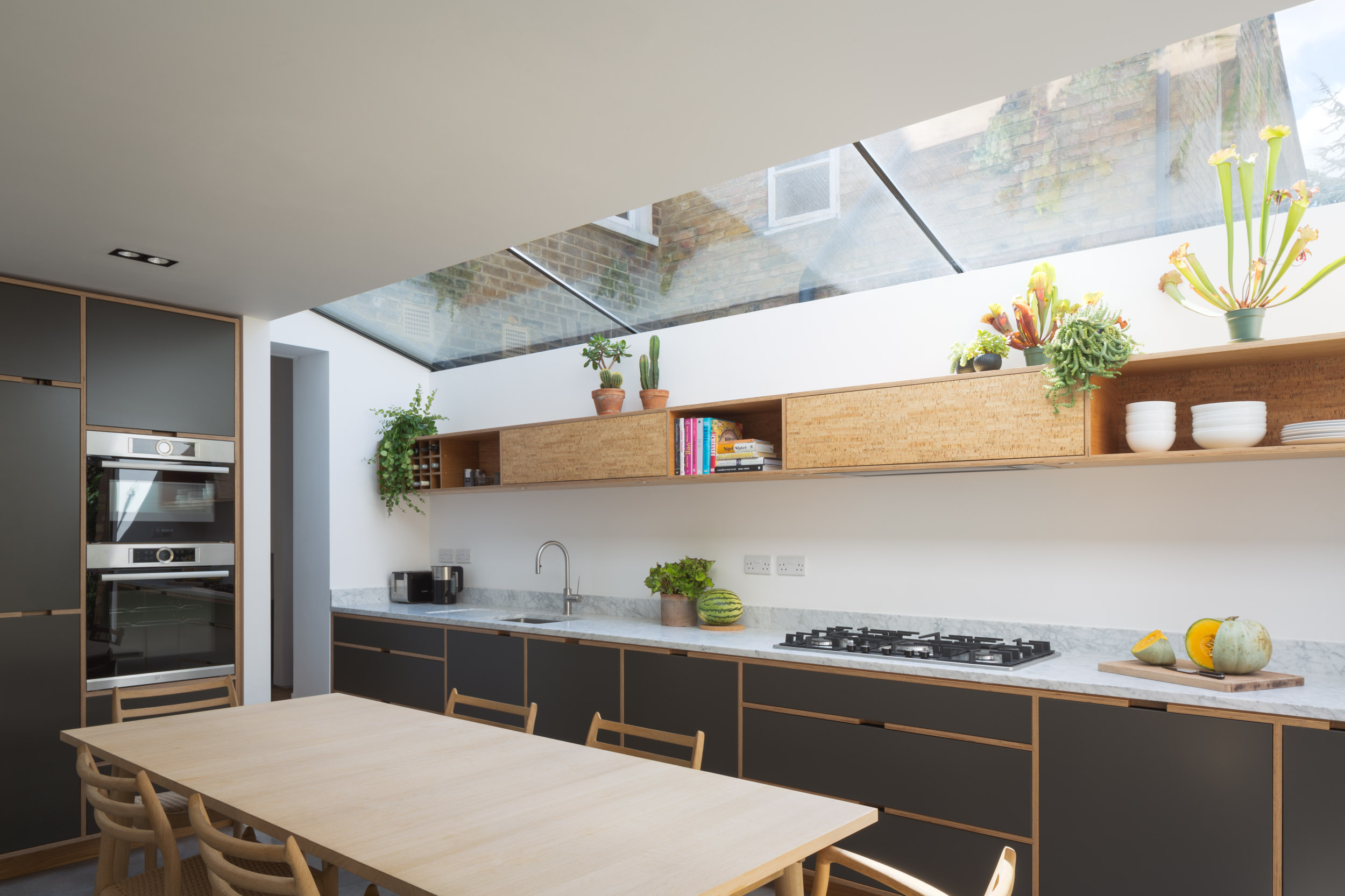 Plywood kitchen in dark grey with skylight, victorian extension
