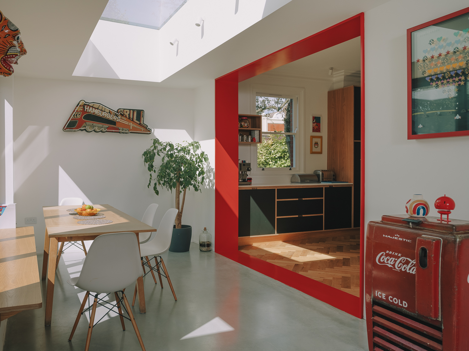 Open plan kitchen diner with bright red open threshold.