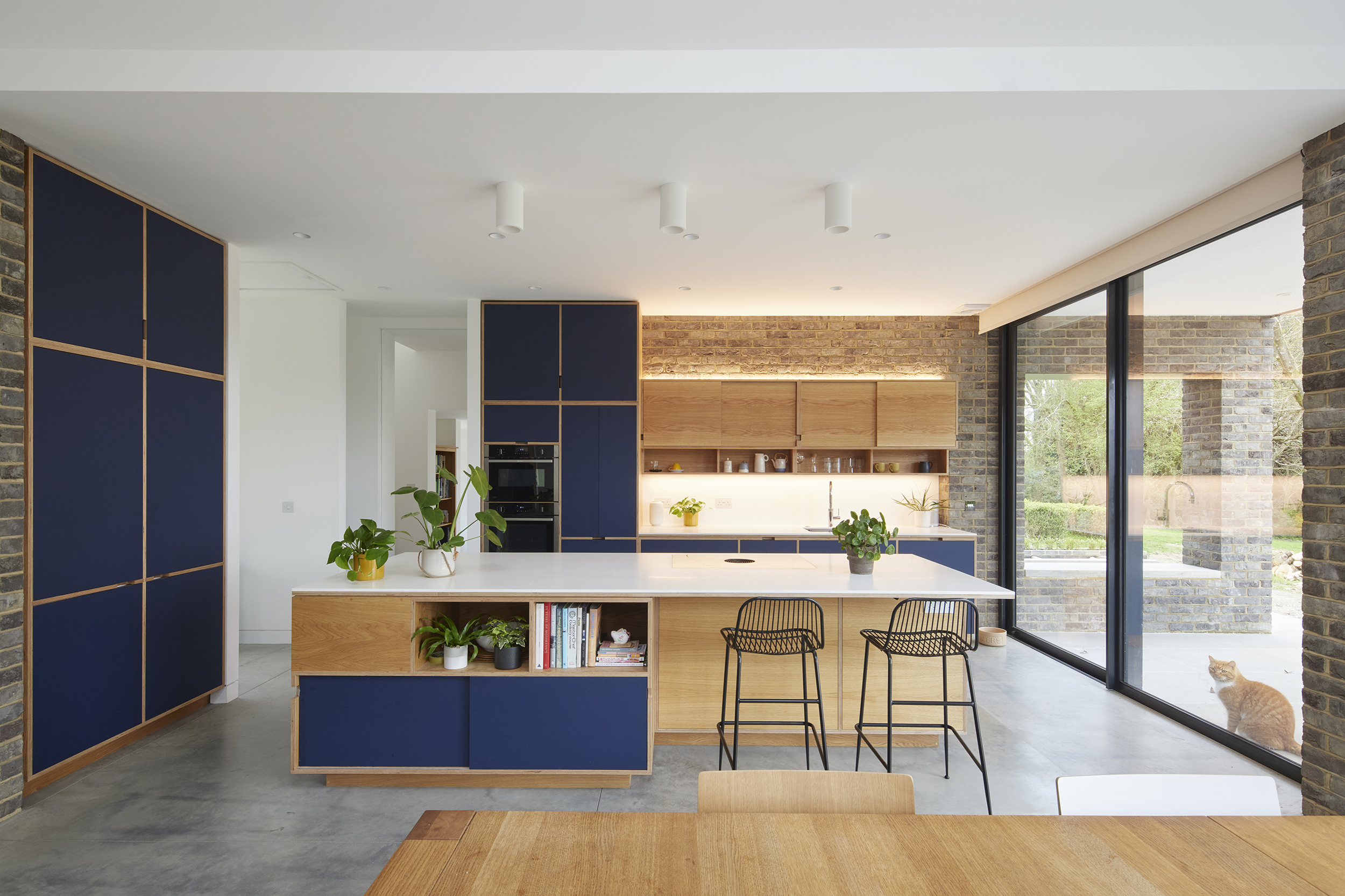 A bespoke open-plan plywood kitchen designed for a period home extension. Discover how Uncommon Projects used architectural planning, oak veneer and navy cabinetry to create a calm, social kitchen filled with natural light.