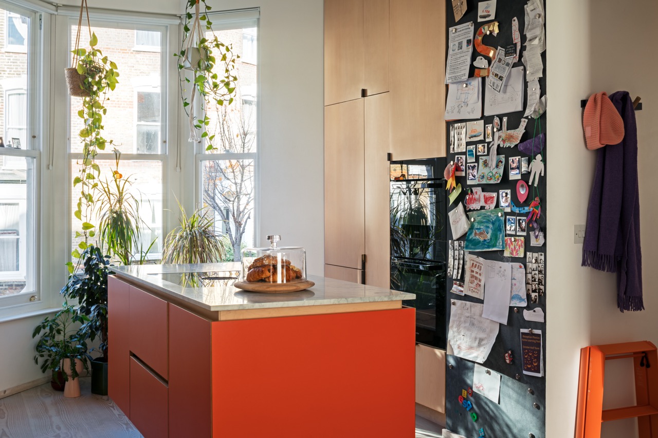 Orange kitchen island and maple veneer oven housing with Miele double ovens, bespoke kitchen Hackney
