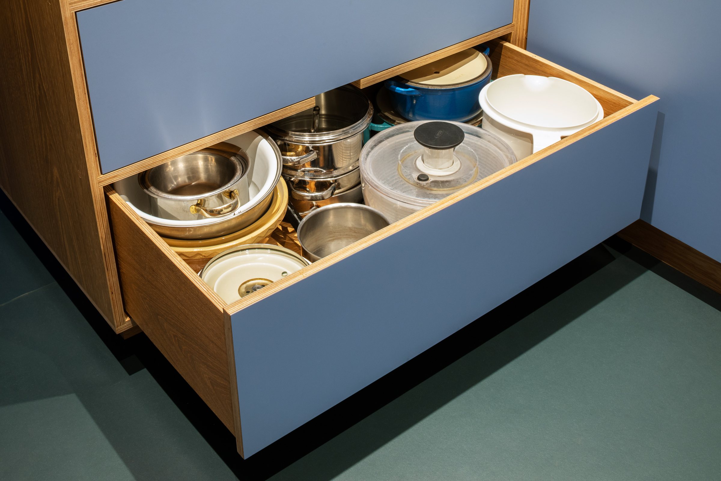 Deep pan drawer in blue laminate and oak plywood, filled with saucepans and mixing bowls