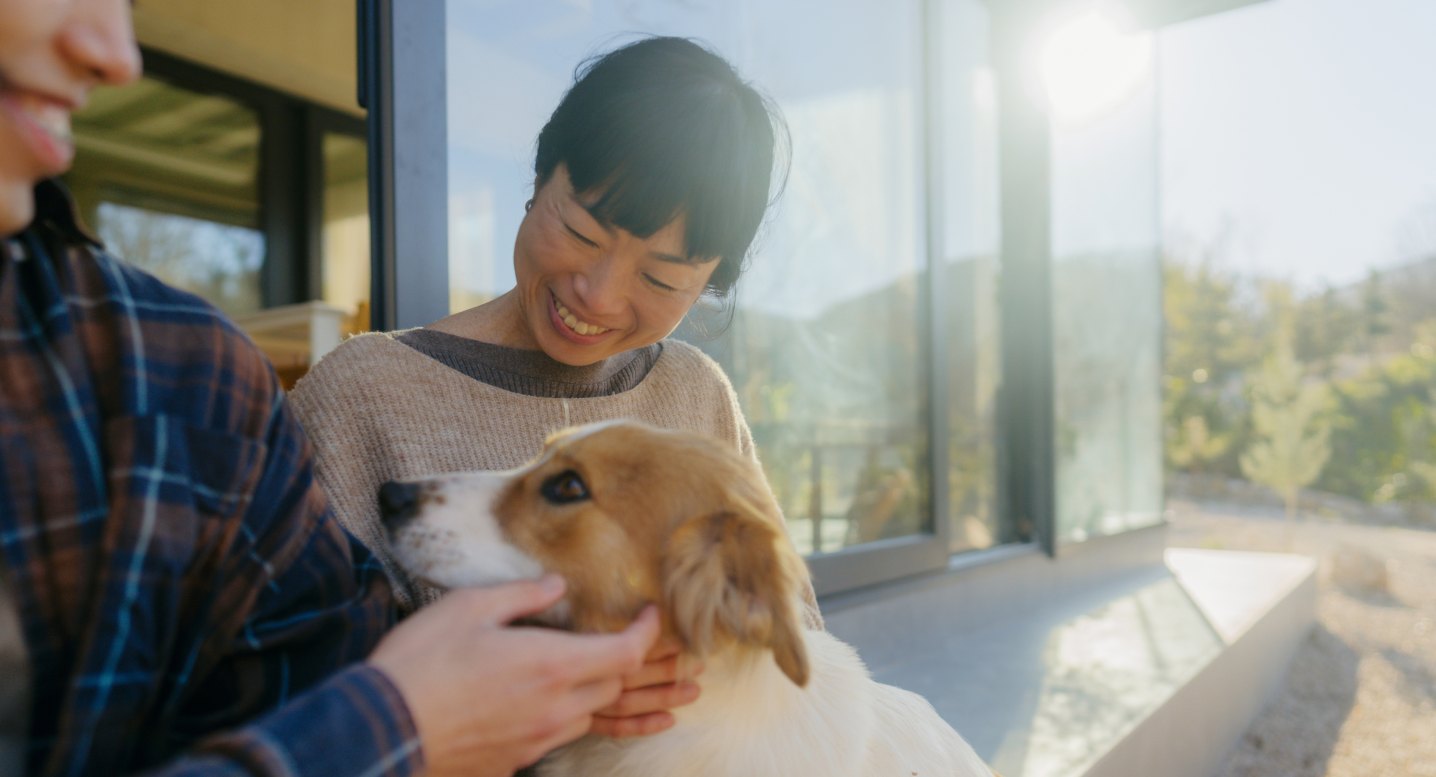 Twin member smiling with her dog at home