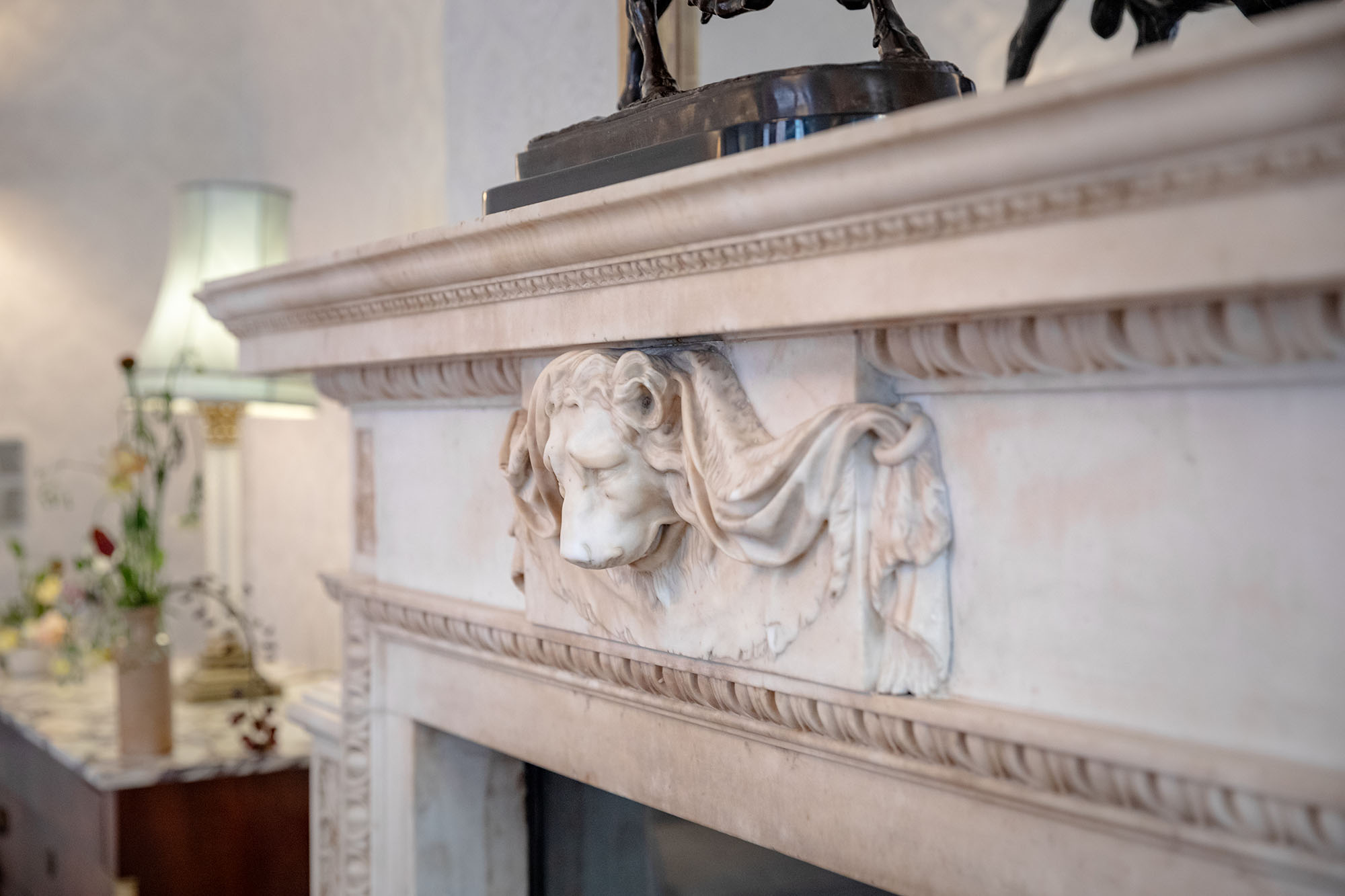 Close-up of an ornate marble fireplace and mantlepiece. 