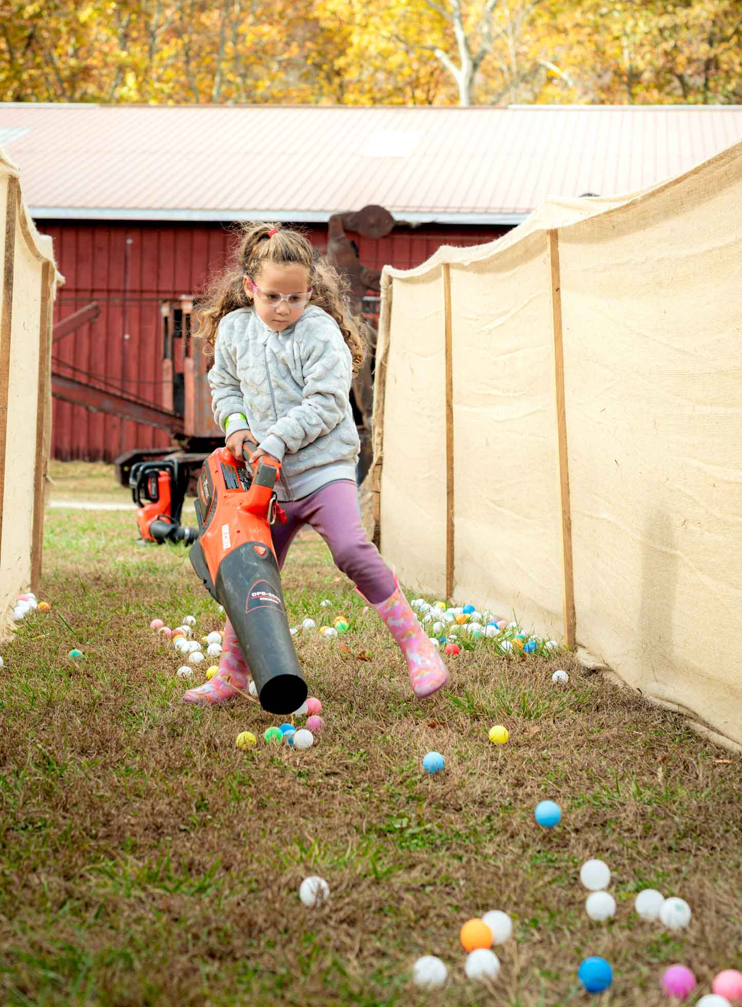 Girl using a leaf blower.