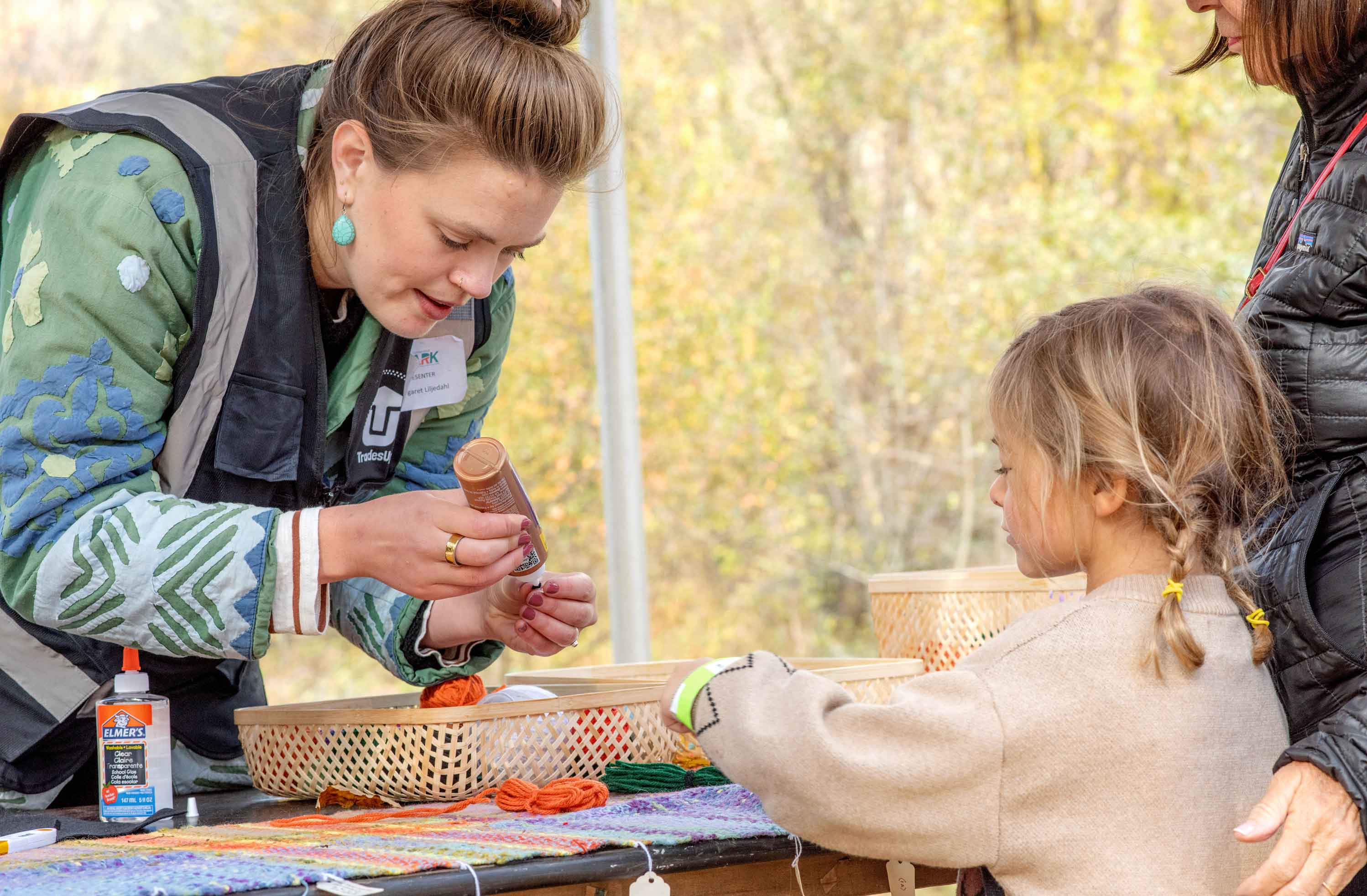 Woman teaching girl crafts.