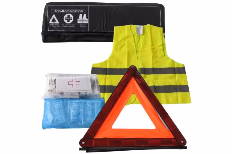 ausgeklapptes Warndreieck, Verbandspaket und Warnweste aufgebreitet