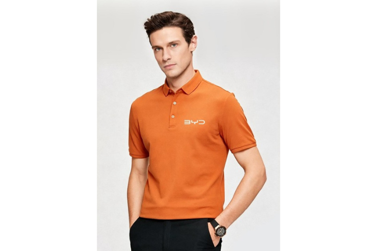 Mann in orangem Poloshirt und weißem BYD Schriftzug auf weißem Hintergrund