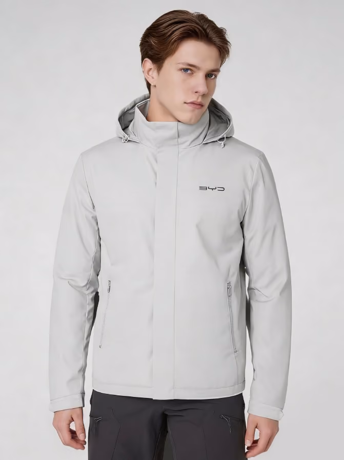 Mann trägt silbergraue Jacke mit Kapuze und BYD Logo auf grauem Hintergrund