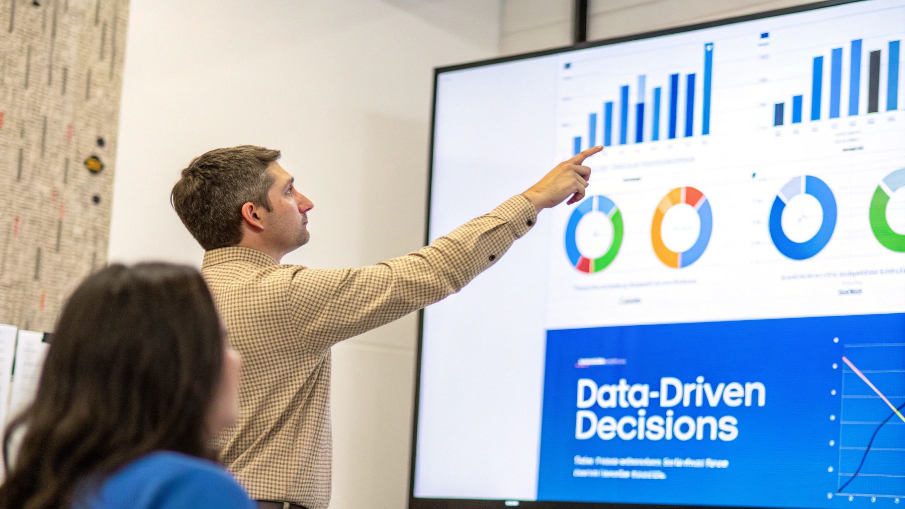 A person pointing at a digital dashboard with charts and graphs, illustrating data-driven decision making.