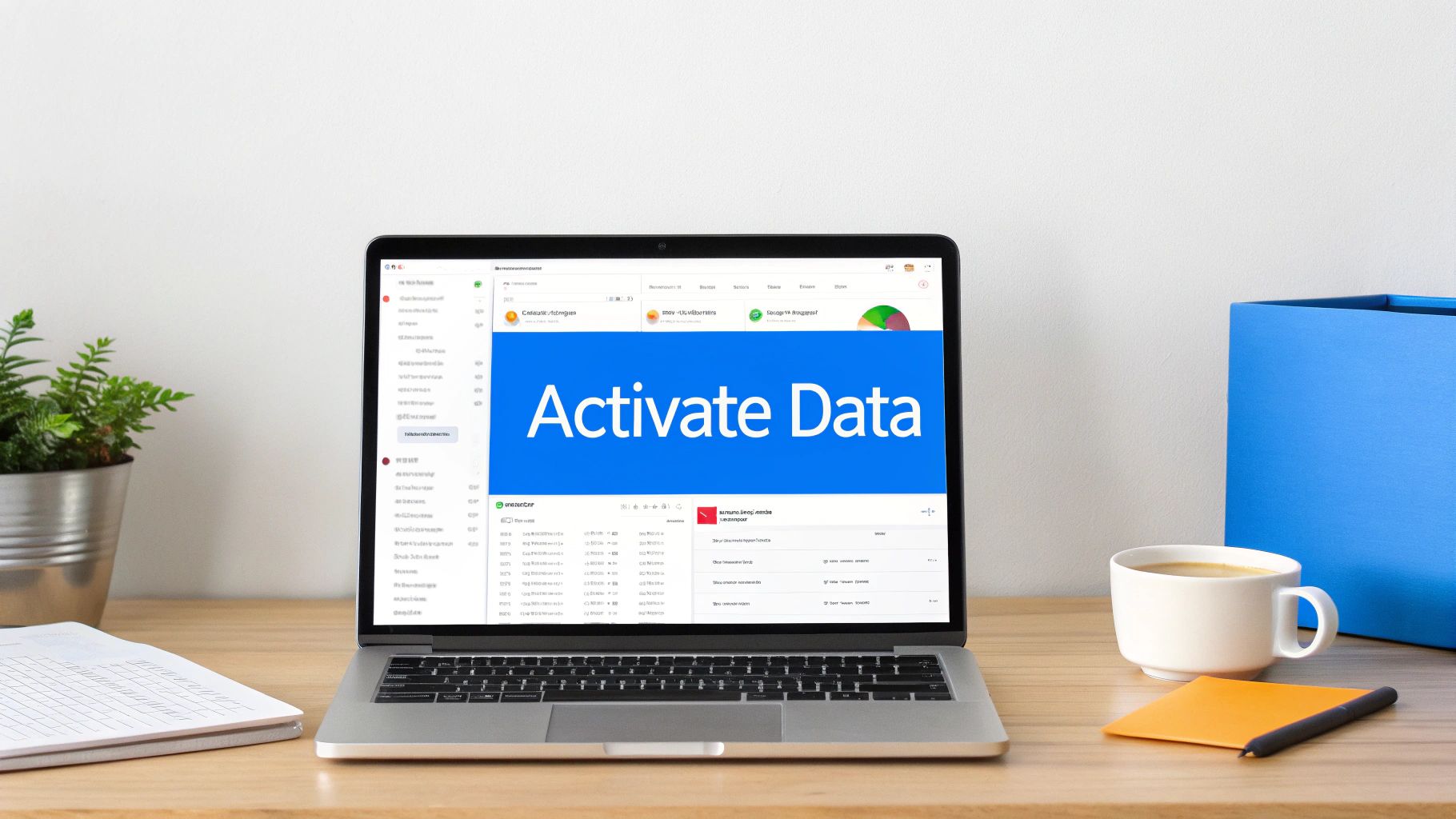 Laptop displaying Activate Data interface on wooden desk with coffee and office supplies