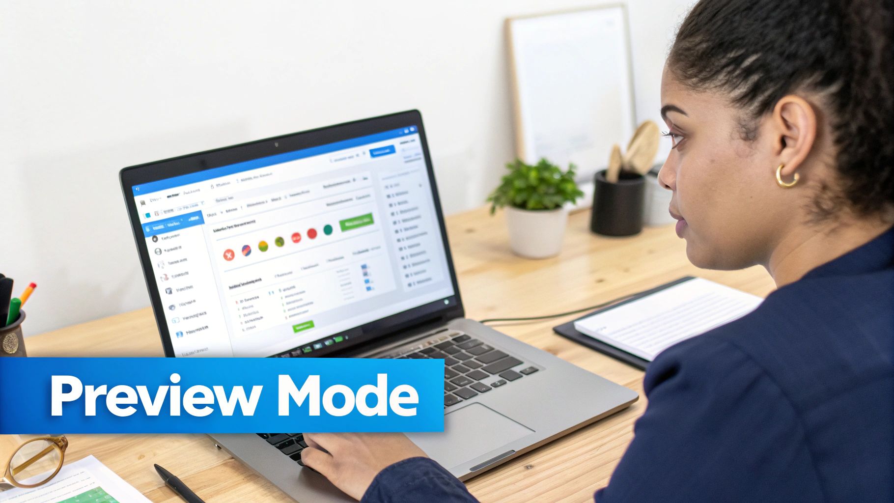 A woman in a blue shirt works on a laptop, viewing a system in preview mode.