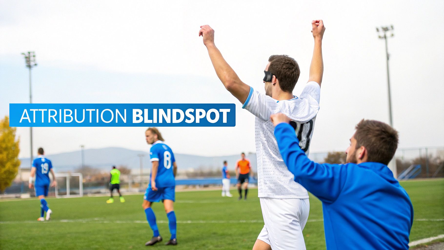 A blindfolded soccer player celebrates a goal with a teammate, illustrating an 'ATTRIBUTION BLINDSPOT'.