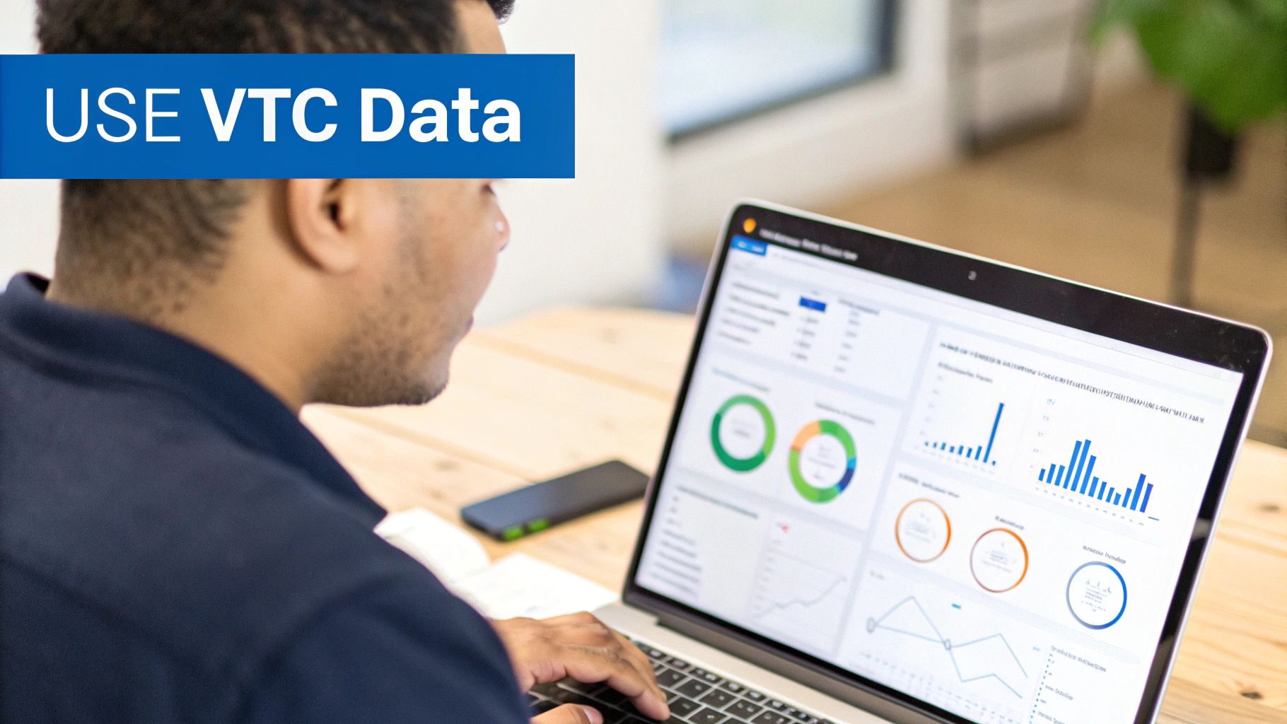 A person views VTC data insights and charts on a laptop, emphasizing data analysis.