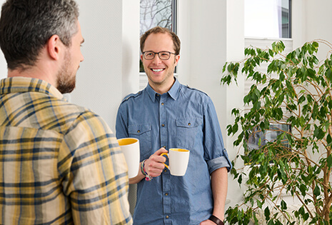 Coffee break in the team: Two colleagues drink coffee together