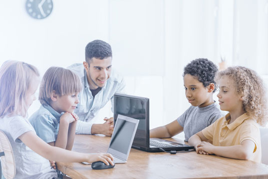 Kids coding on laptops